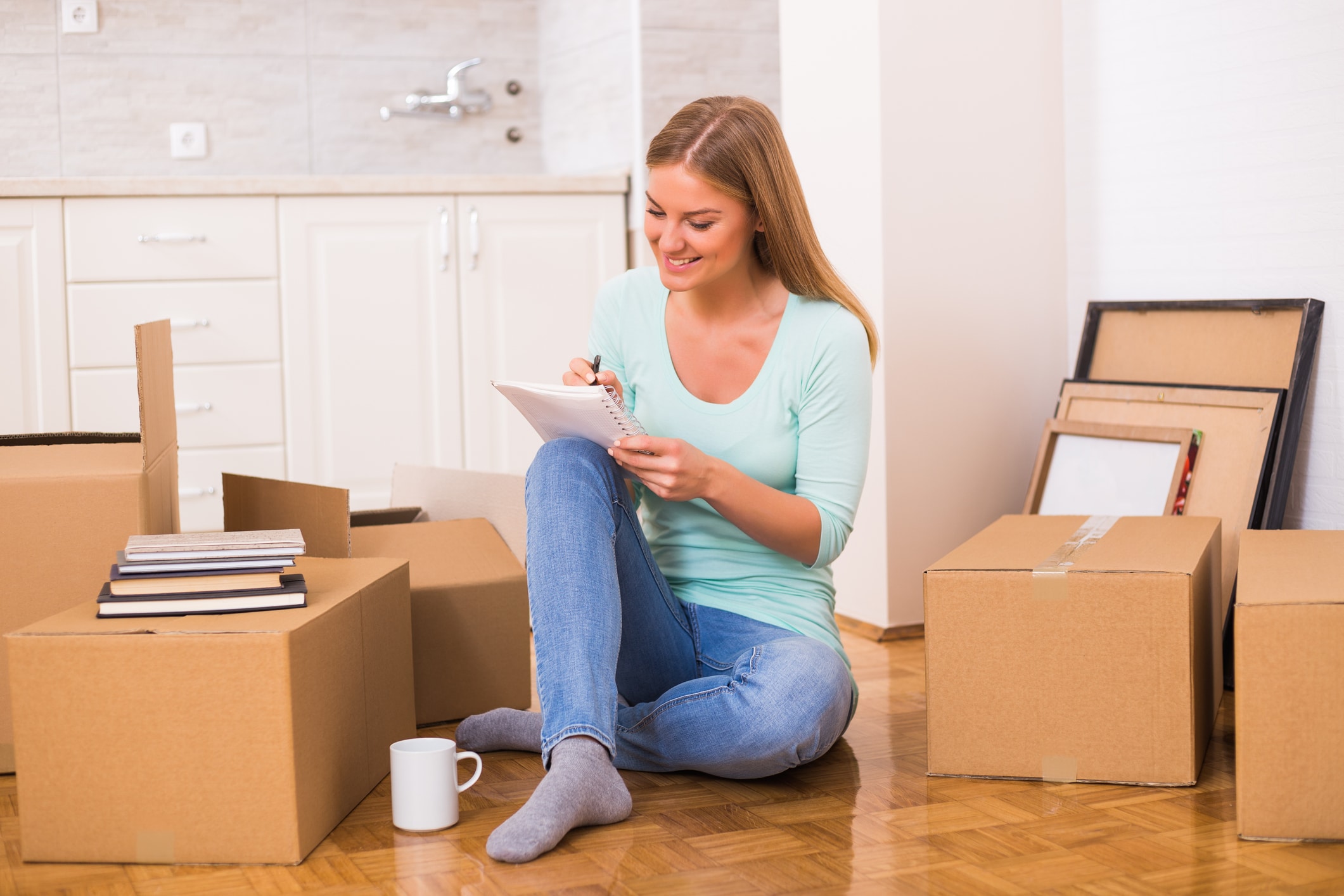 A woman happily ticking off her checklist as she packs for moving long-distance