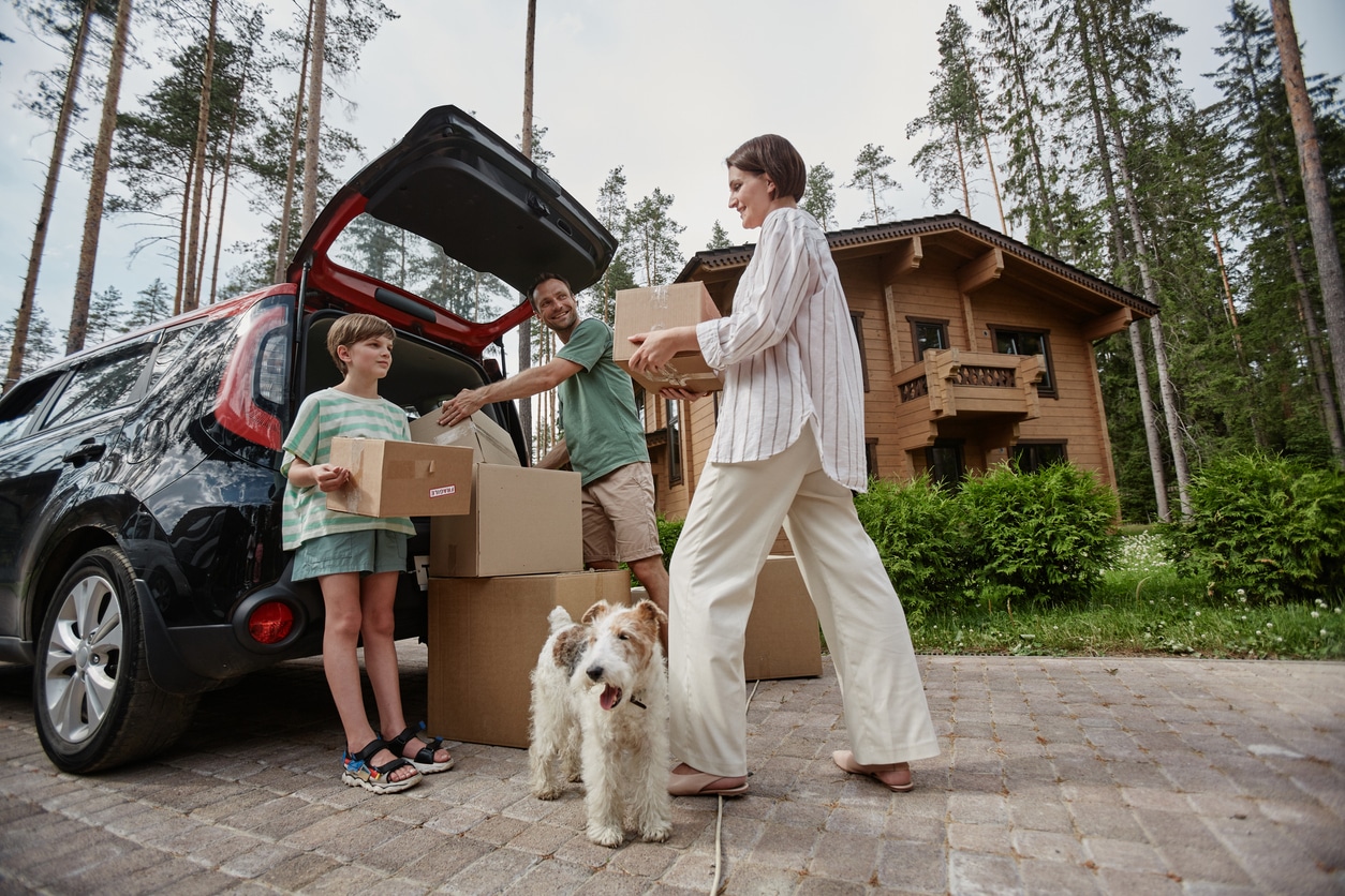 A family loads luggage and bags as they get ready to transport a vehicle to another state