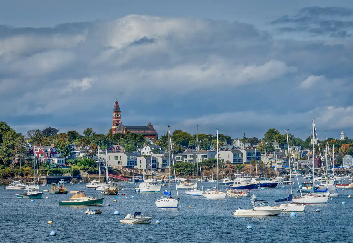 Marblehead Harbor in Massachusetts with sailboats and waterfront buildings under clear skies
