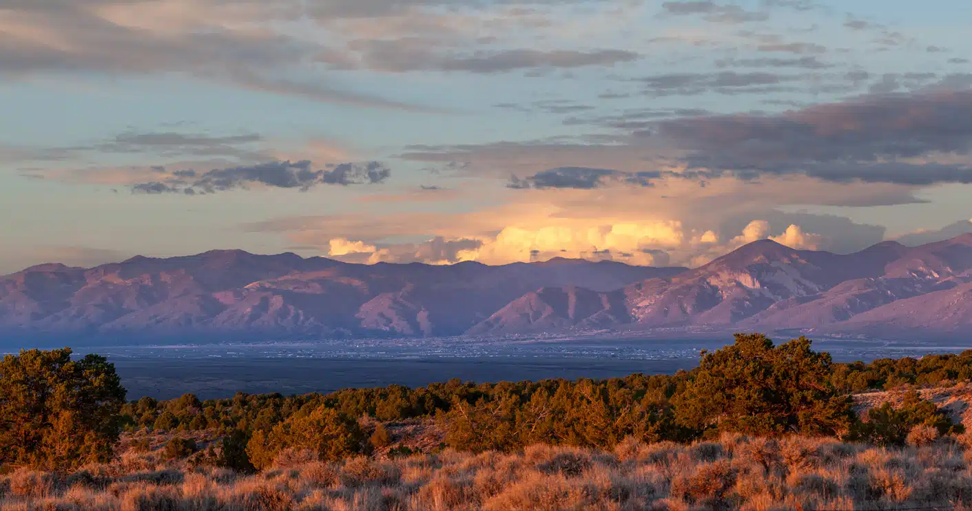Sangre de Cristo Mountains in Taos Valley, New Mexico, at sunset, with golden and purple clouds