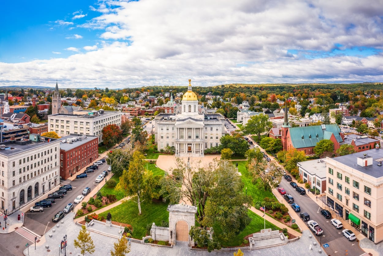 An aerial view of the New Hampshire State House with its golden dome, evoking the beauty of living in New Hampshire