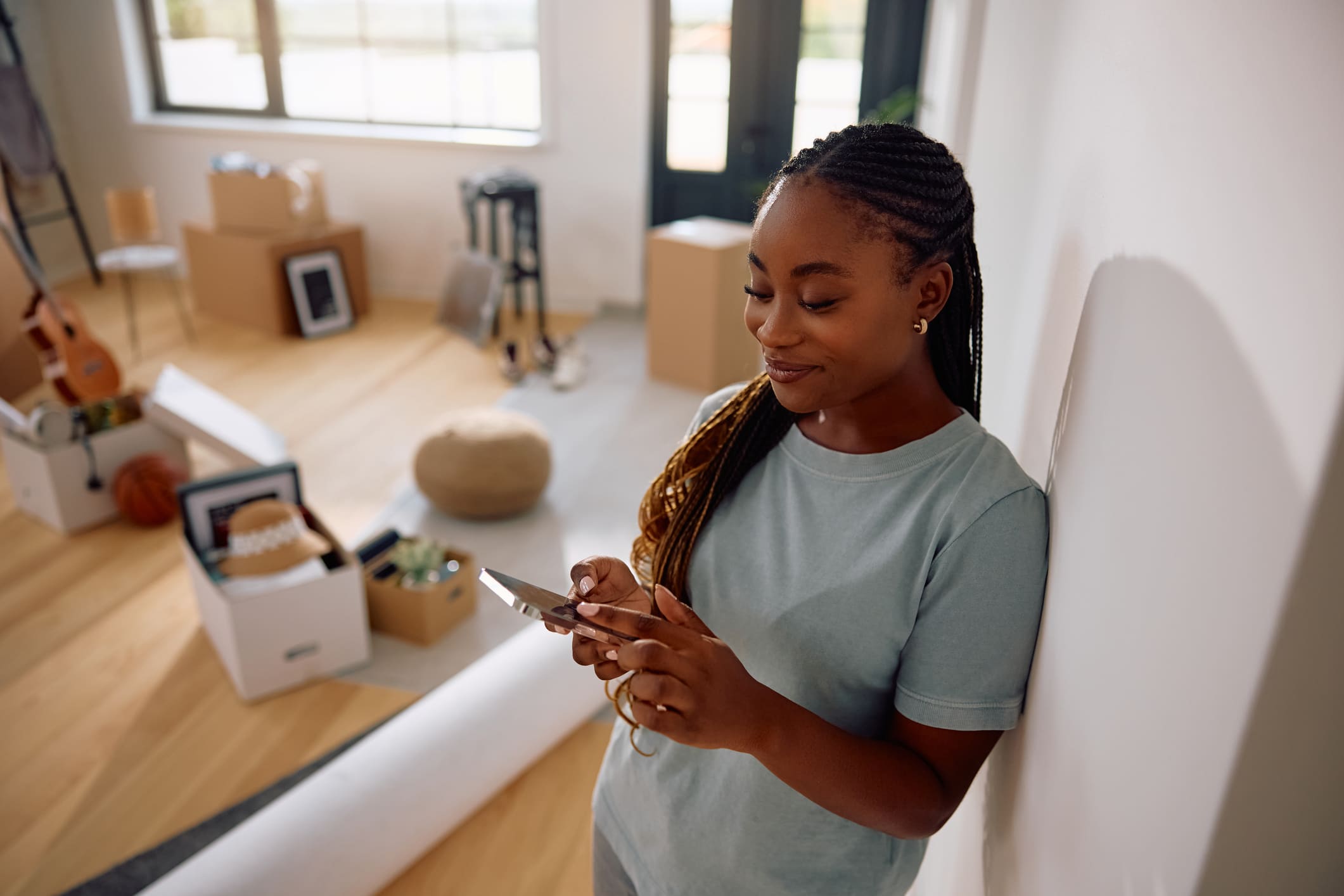 A Black woman using the best moving apps on her phone to make her move easier