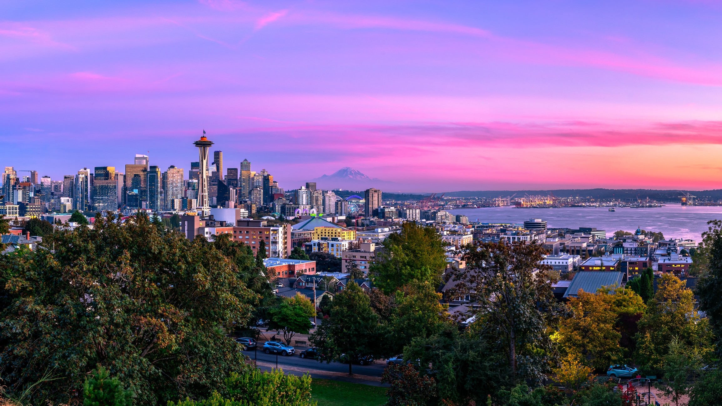 Seattle skyline at sunset, with the Space Needle and Mount Rainier, capturing the beauty of living in Seattle