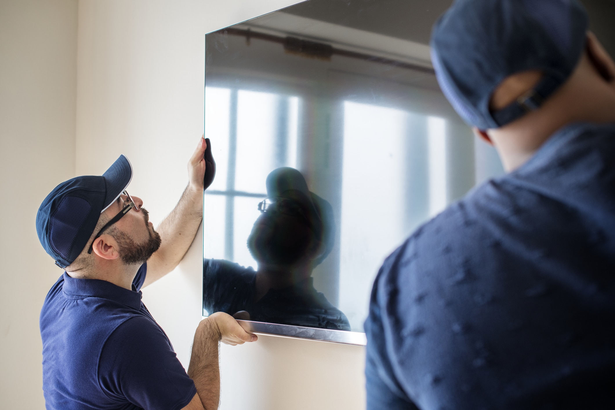 Two professional movers demonstrate how to pack a TV for moving safely