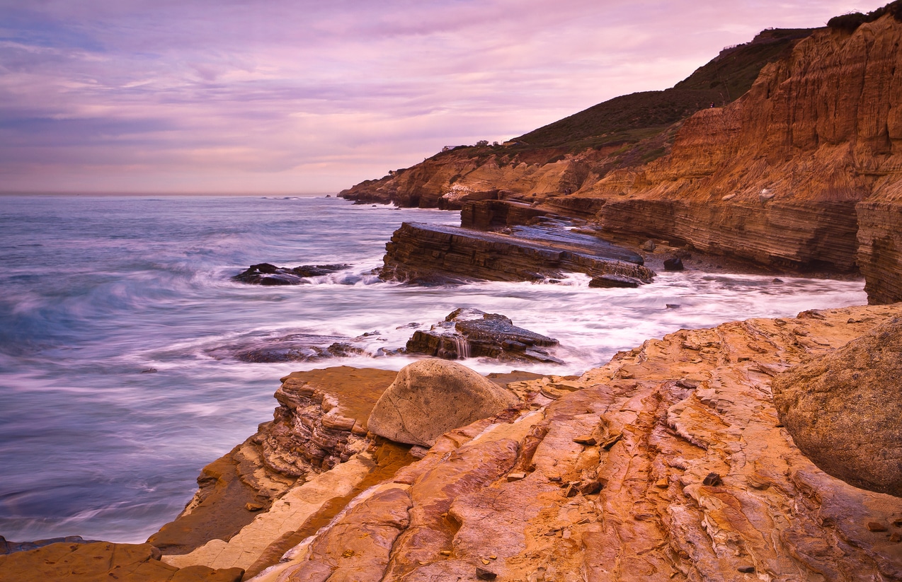 Tide Pools in Cabrillo National Monument San Diego, California A scenic view of waves crashing against rocky cliffs and tide pools, a beautiful sight for those moving to San Diego