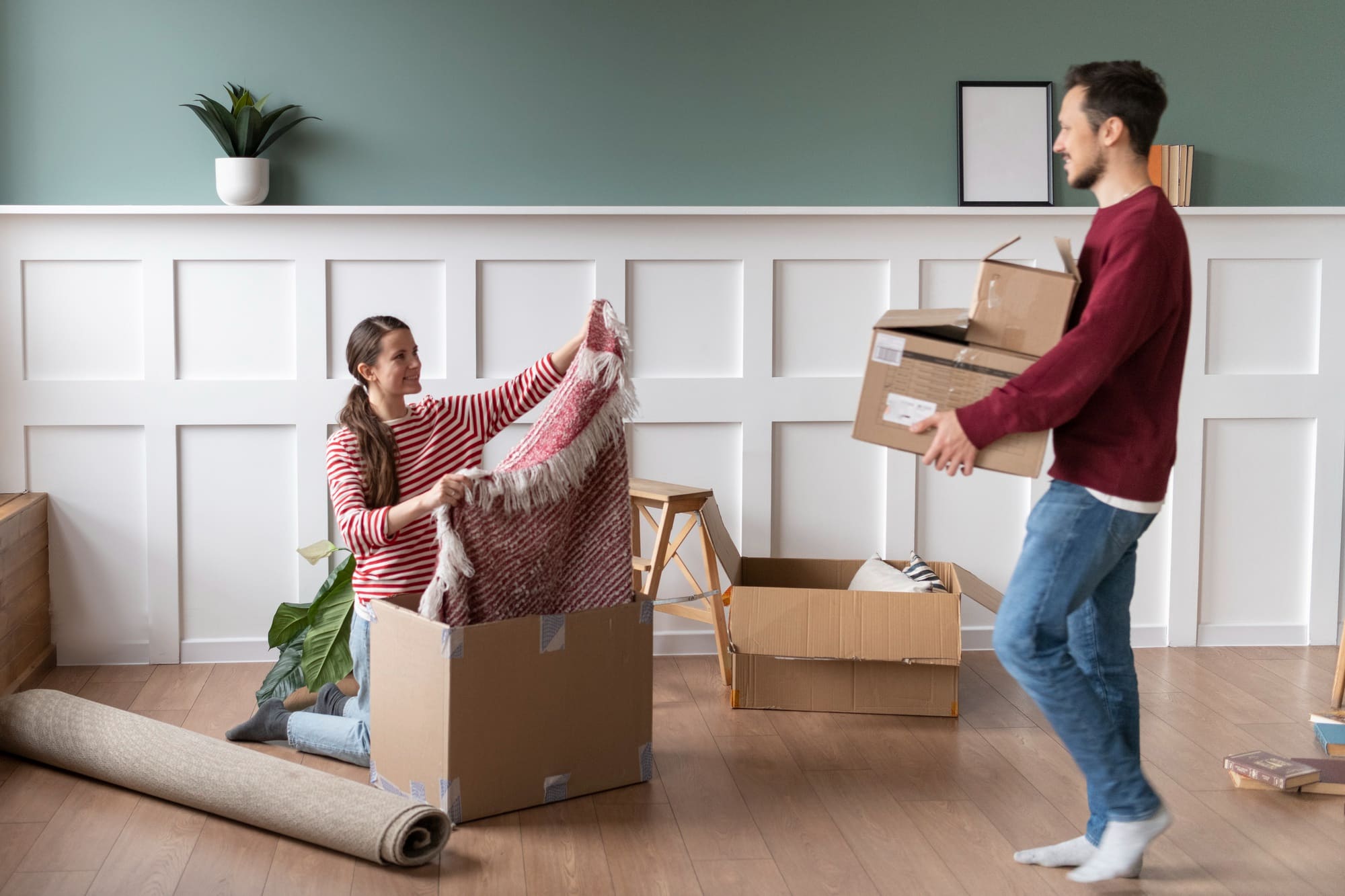 A couple packing their belongings according to their moving out checklist