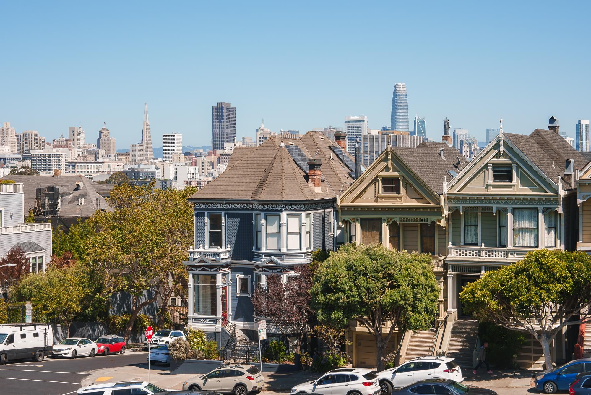 Colorful Victorian houses in front of a city skyline, featuring iconic architecture in one of Chicago’s best neighborhoods