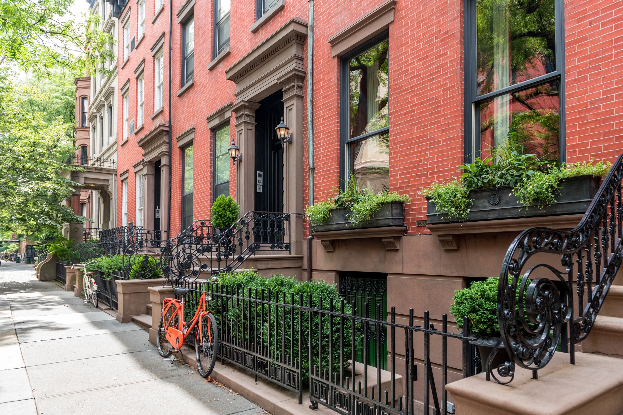 Iconic Greenwich Village brownstones, showcasing the classic charm and greenery of one of the best Manhattan neighborhoods