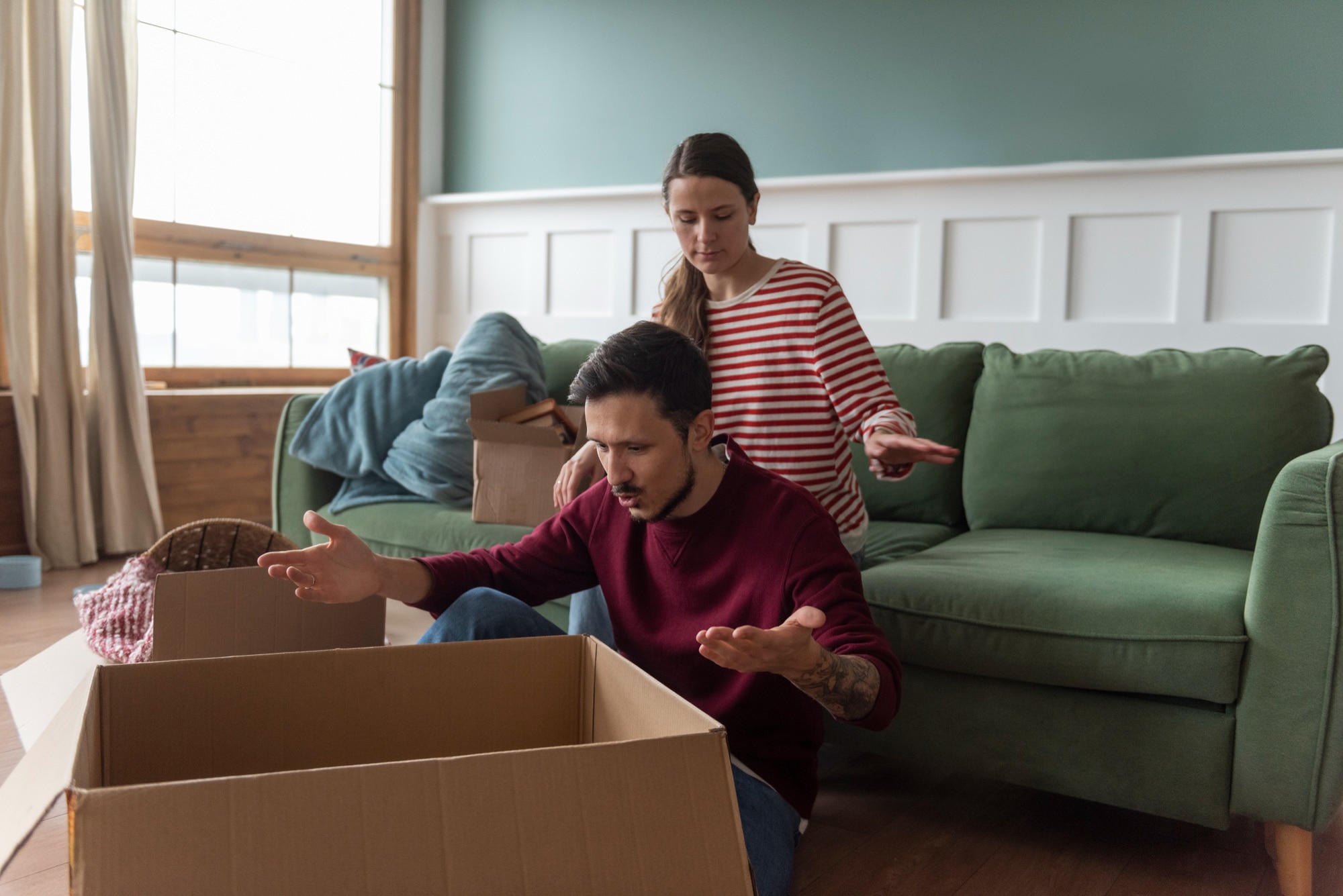 A couple packing household items in boxes, preparing for a move to one of the best Manhattan neighborhoods