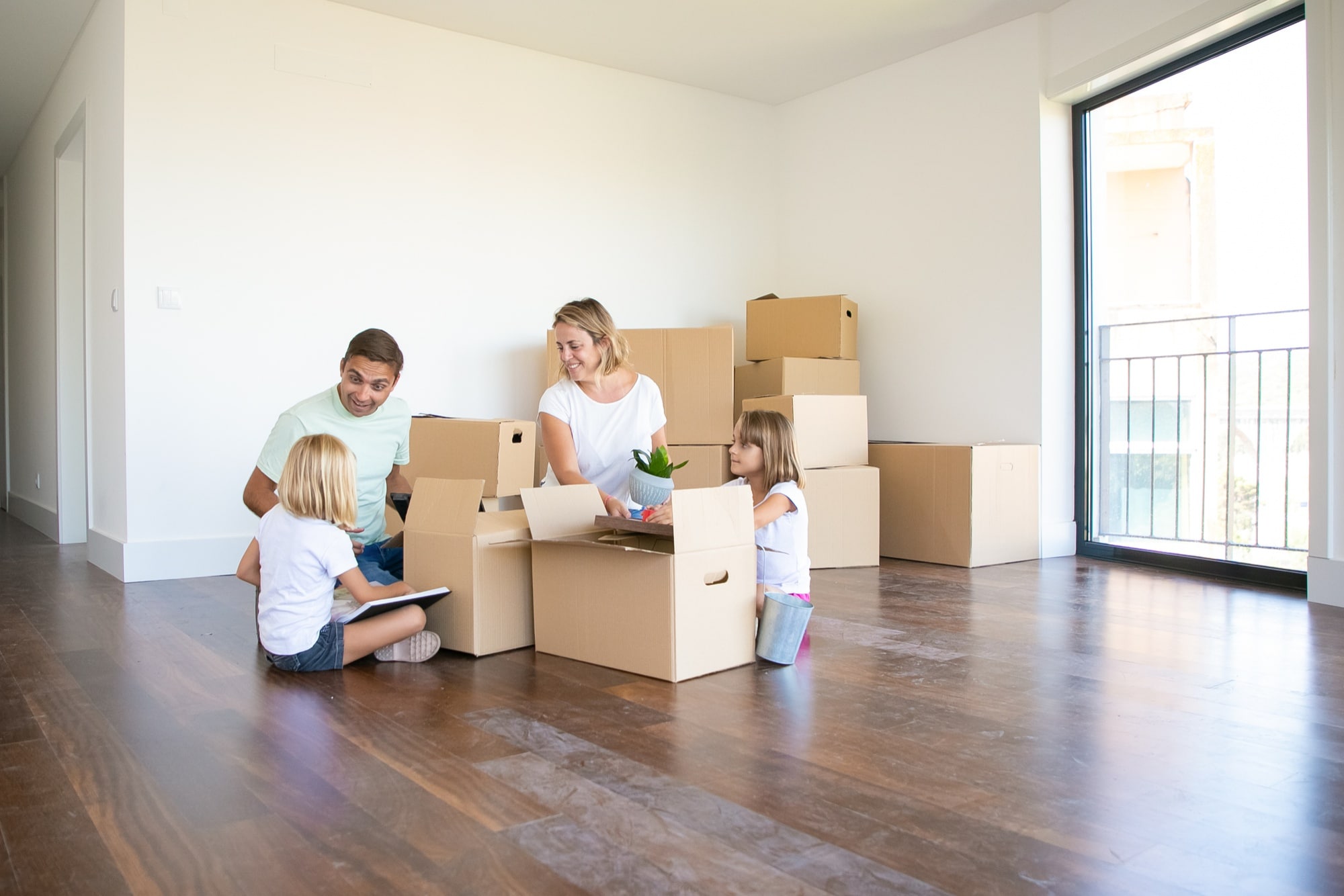 A family of four happily packing their moving boxes