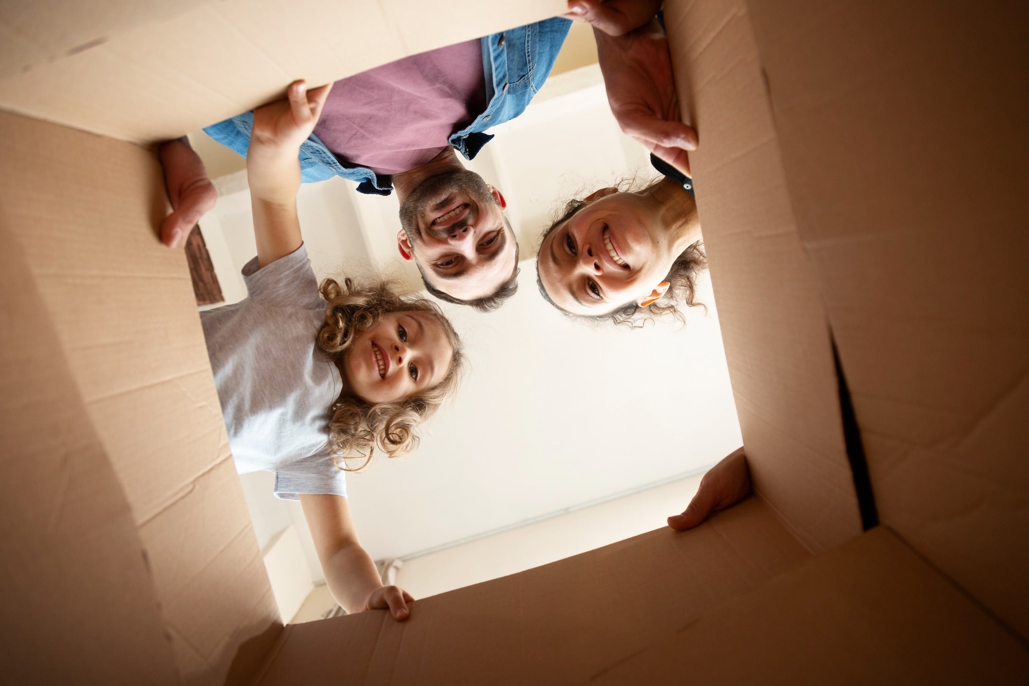 A family of three happily checking if their belongings are ready and complete on moving day