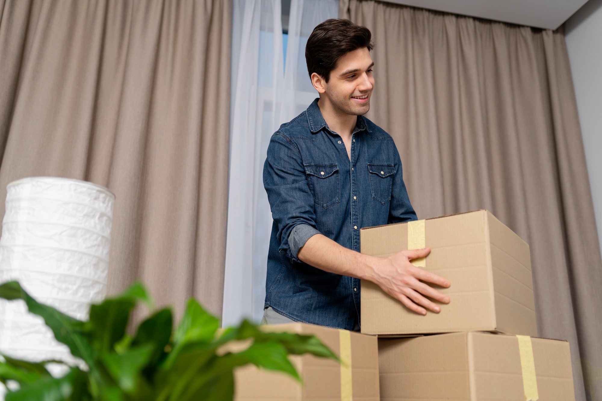 Man packing belongings into boxes for professional cross-country movers to pick up and move from New York to California