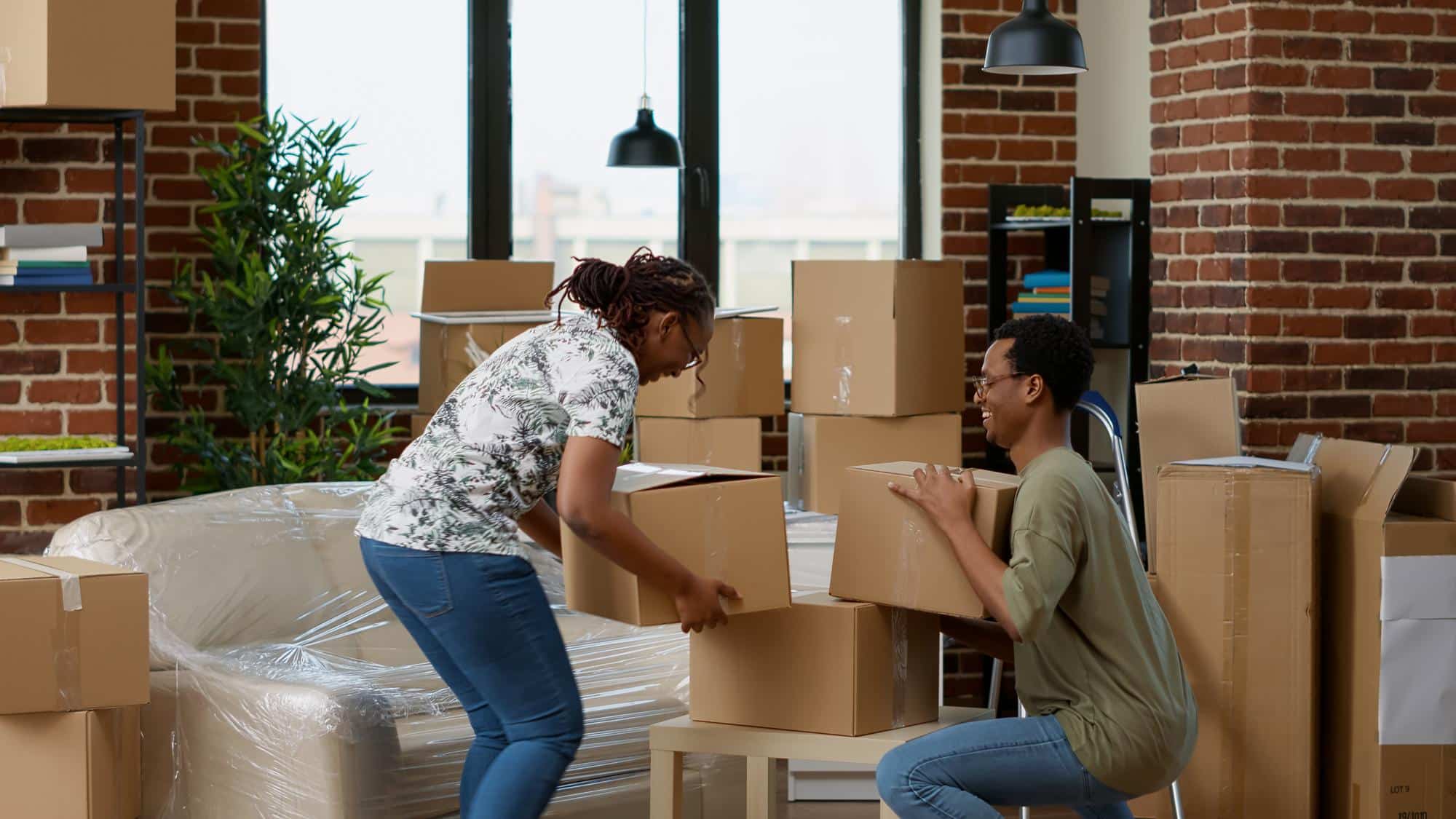 A couple happily handling boxes on Boston moving day