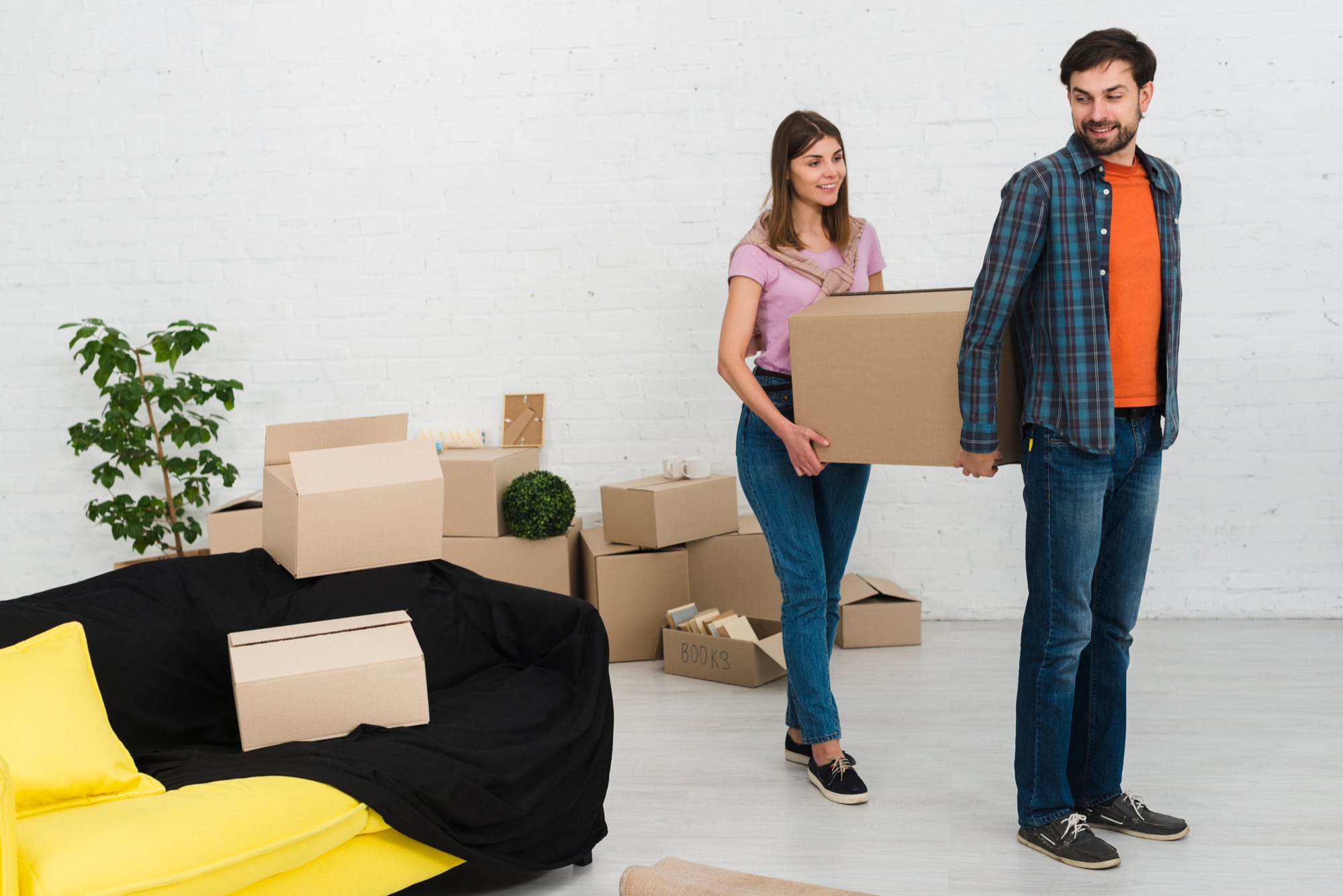 A couple carrying a moving box for their move to Boston