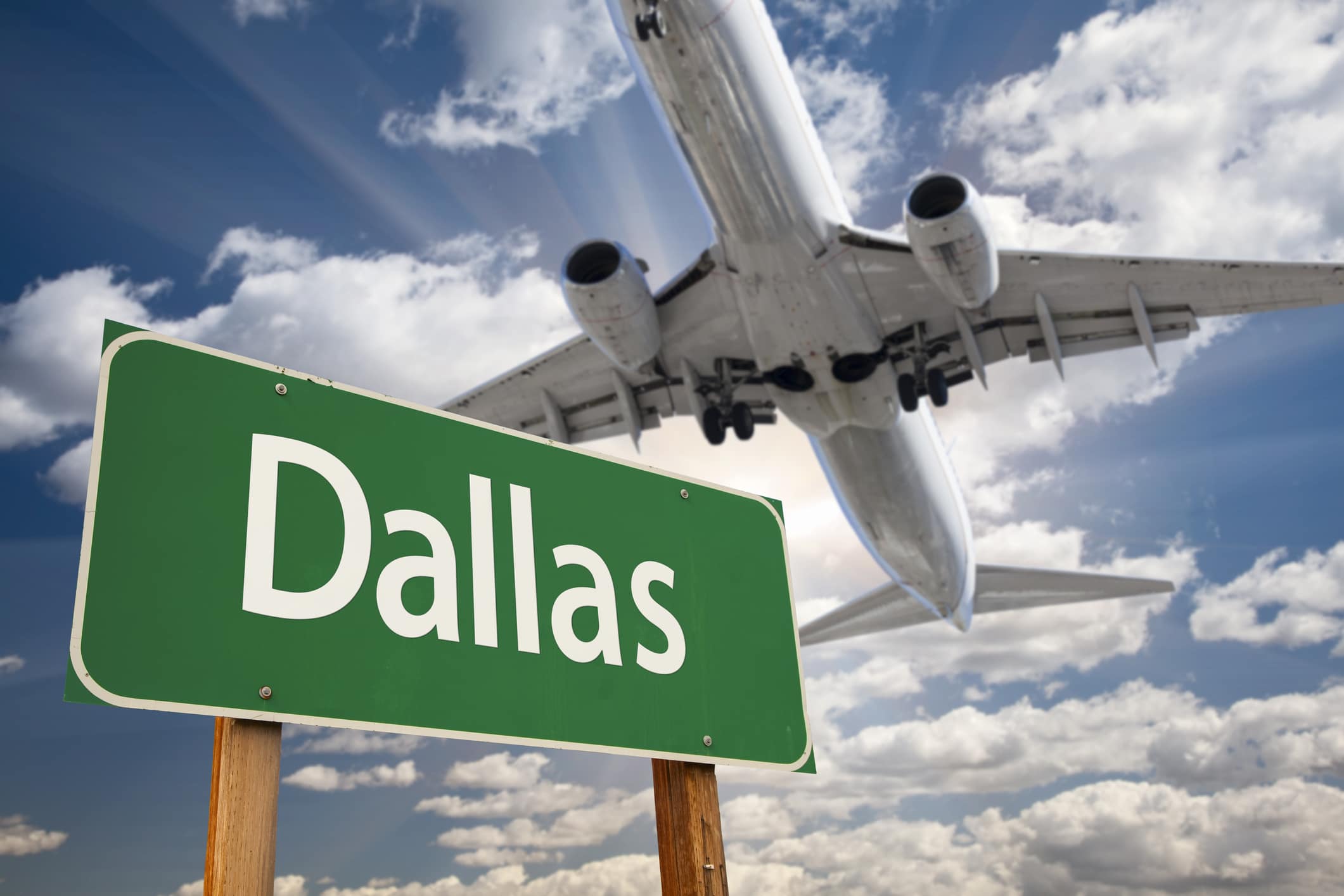 Airplane flying over a Dallas sign, symbolizing the ease of moving to Texas for new opportunities and a fresh start