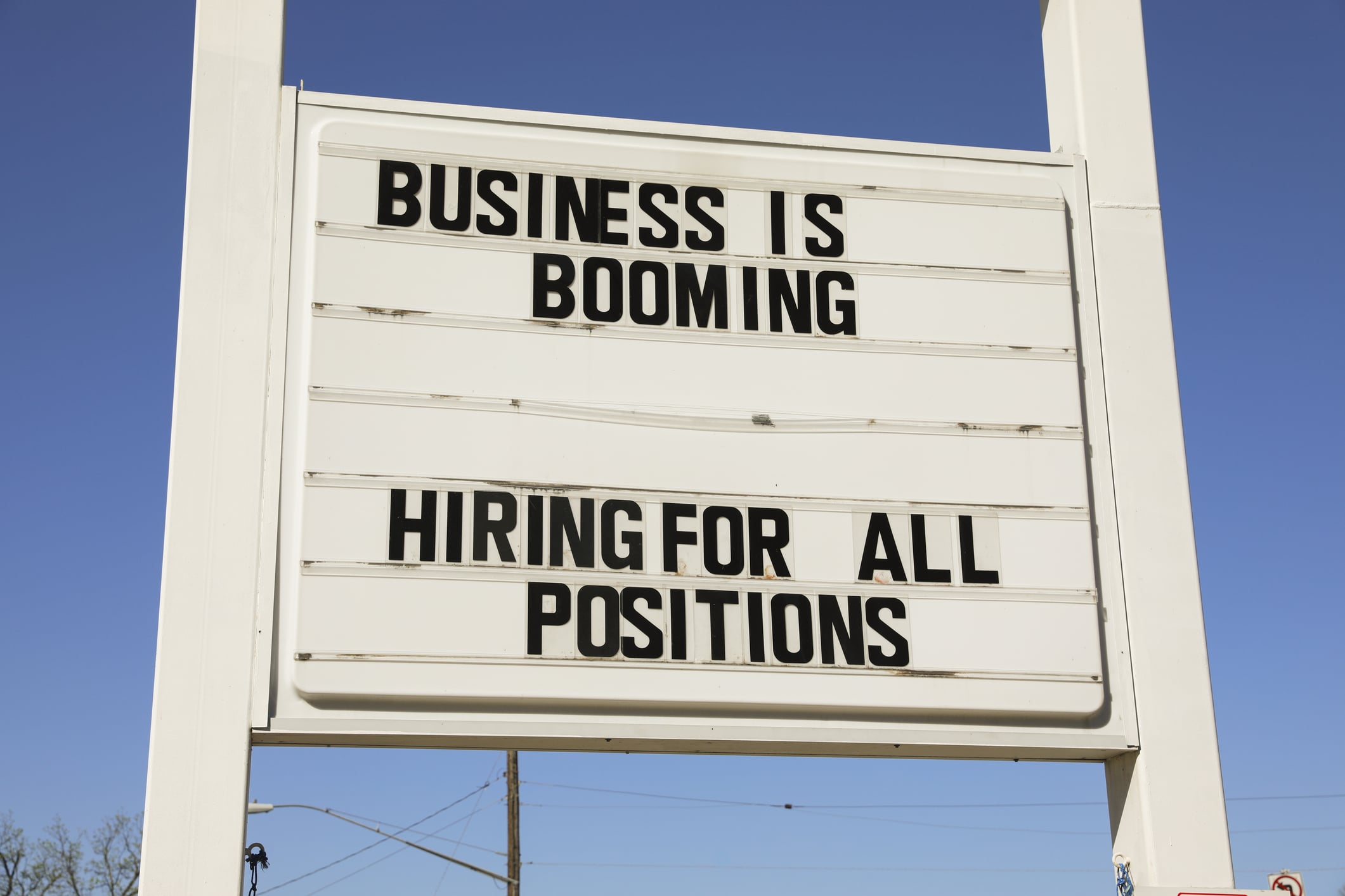 Signage that reads "Business is Booming,” emphasizing Texas's strong job market with growth in tech, energy, and biotech