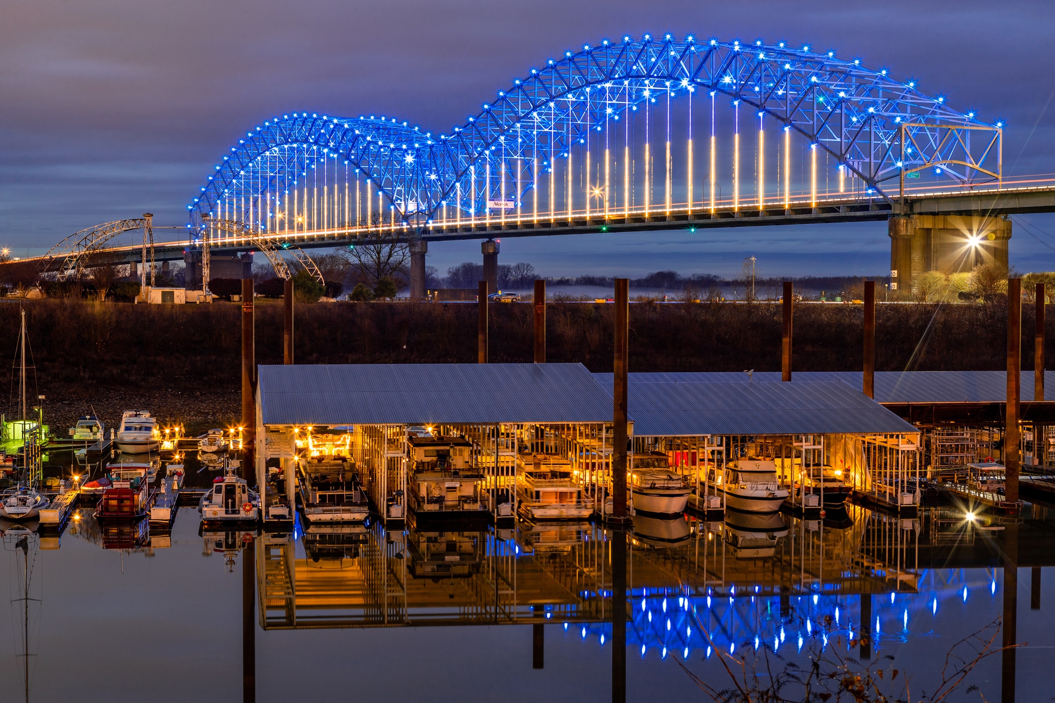 The Hernando de Soto Bridge illuminated in blue over the Mississippi River, a scenic highlight for those moving to Tennessee