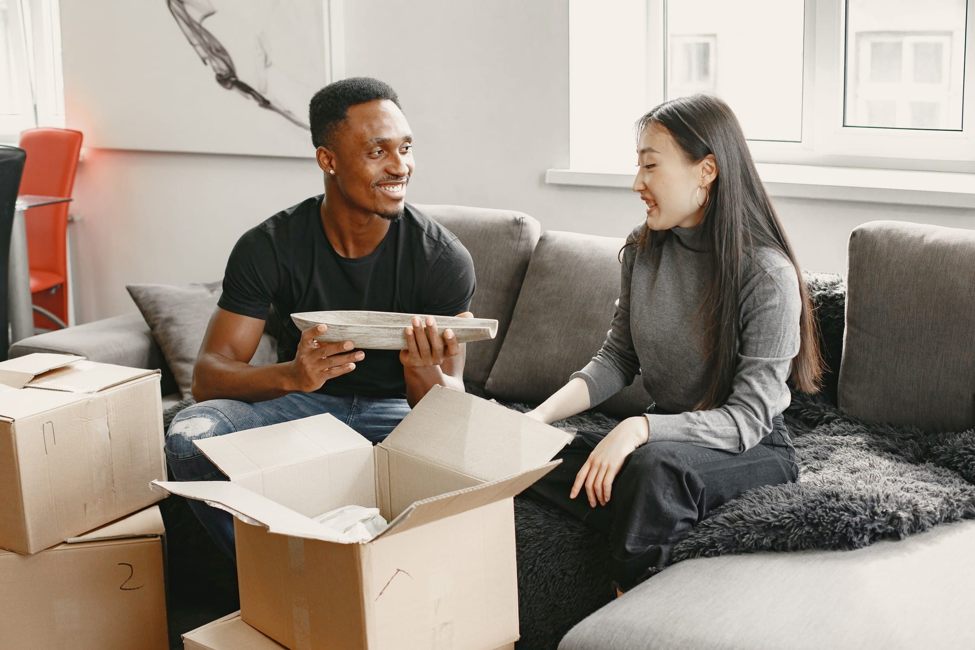 A couple securely packing their dishes for moving