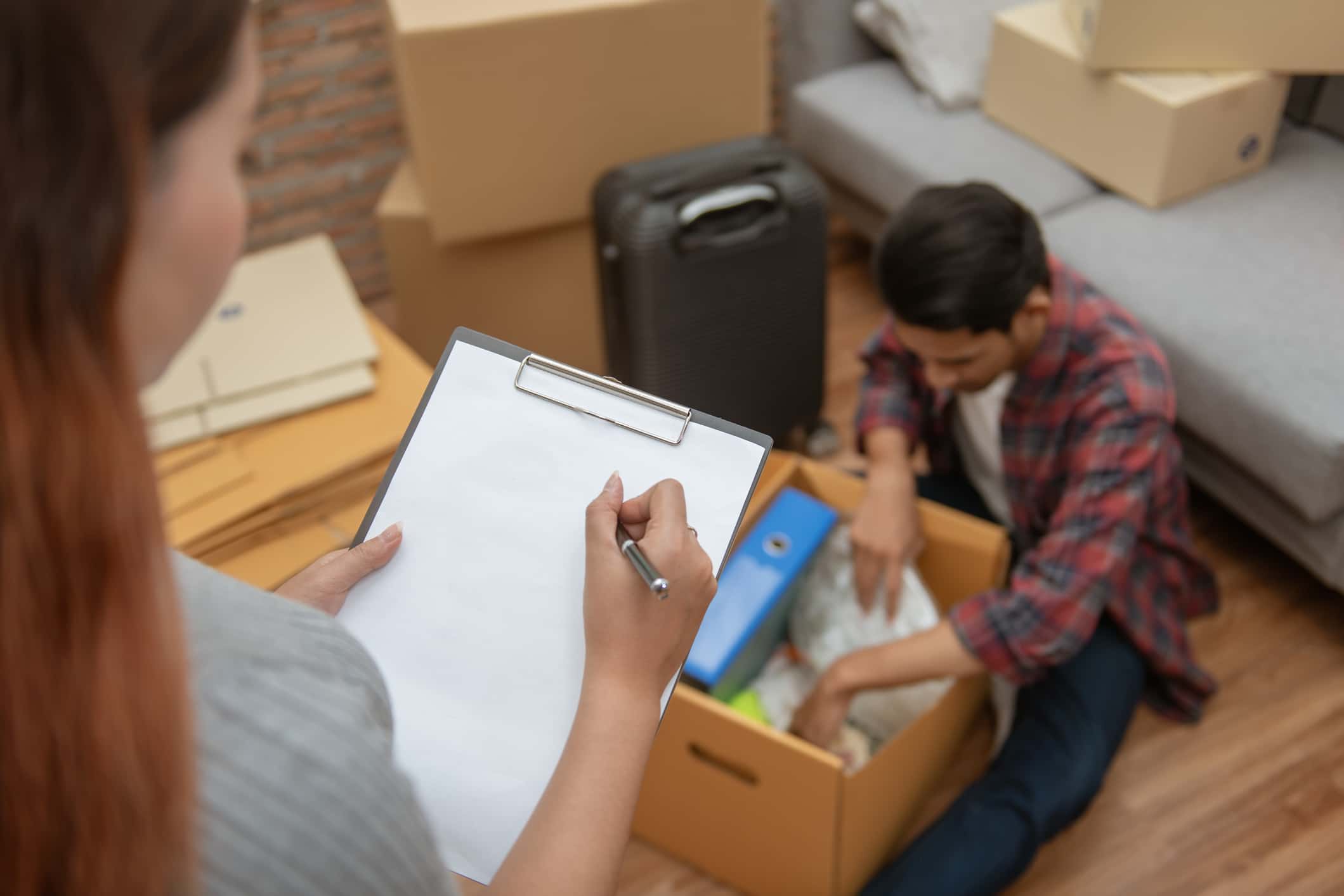 A couple reviews their master inventory list of boxes, demonstrating how to pack for a move effectively