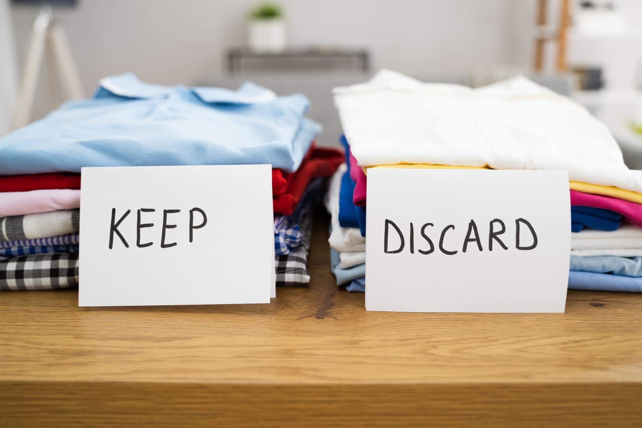 Decluttering clothes by sorting them into keep and discard piles, an essential step in packing for a move