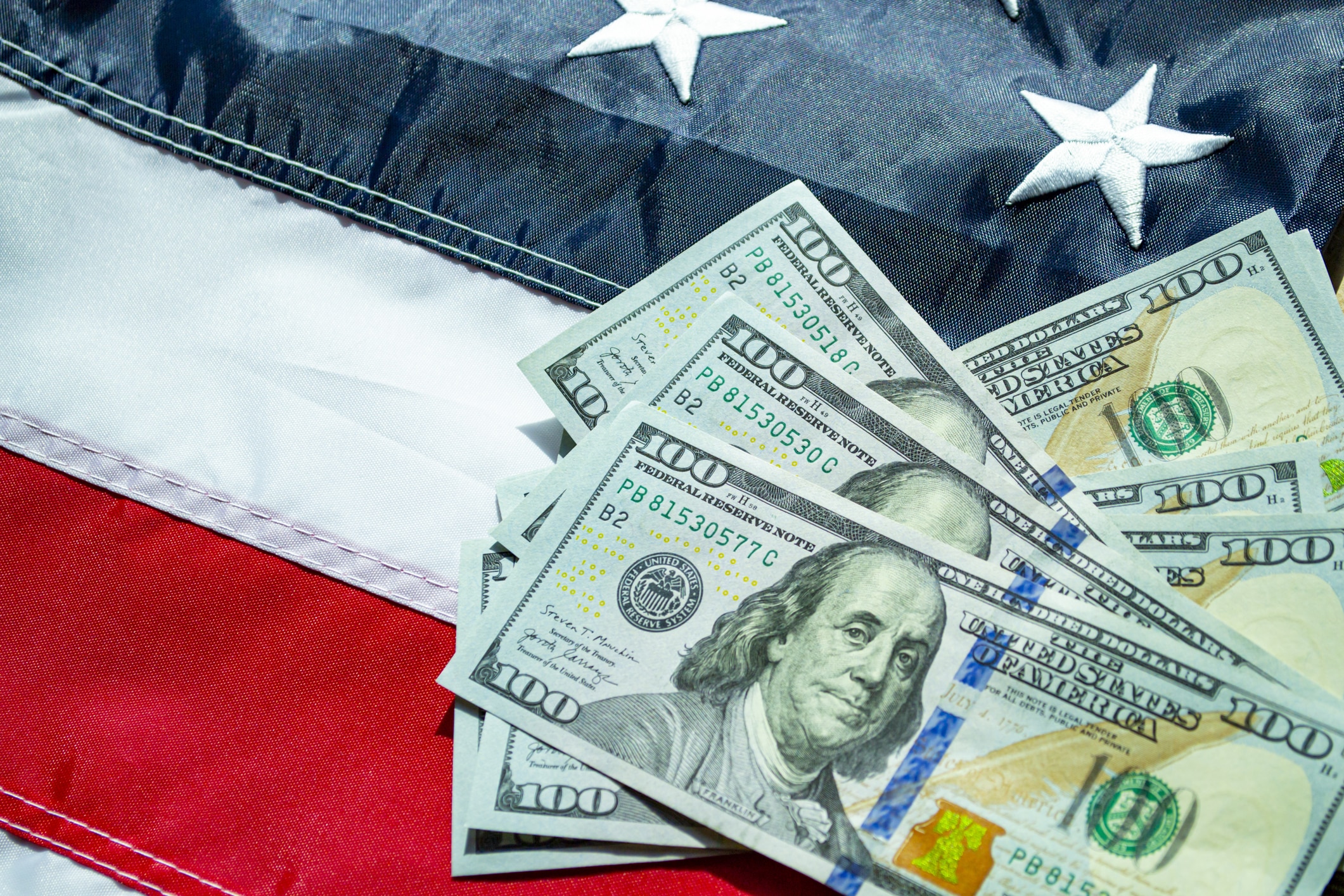 100-dollar bills on an American flag, highlighting the cost of living in Austin, Texas