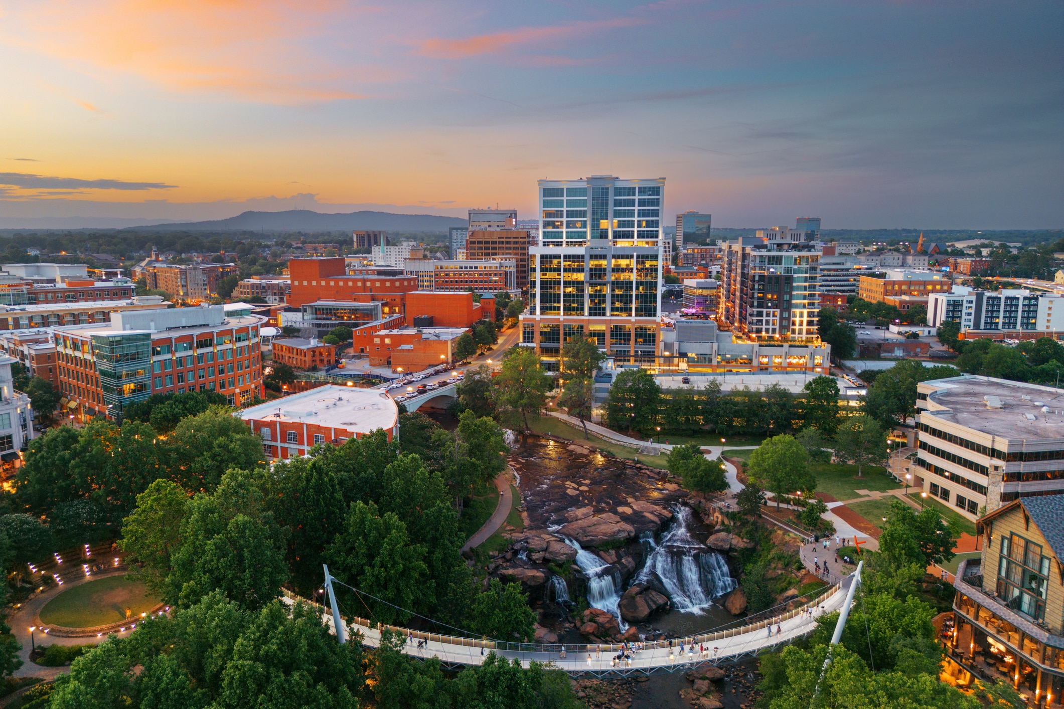 Downtown Greenville and Falls Park on the Reedy glow at sunset, offering unmatched charm for those moving to Greenville