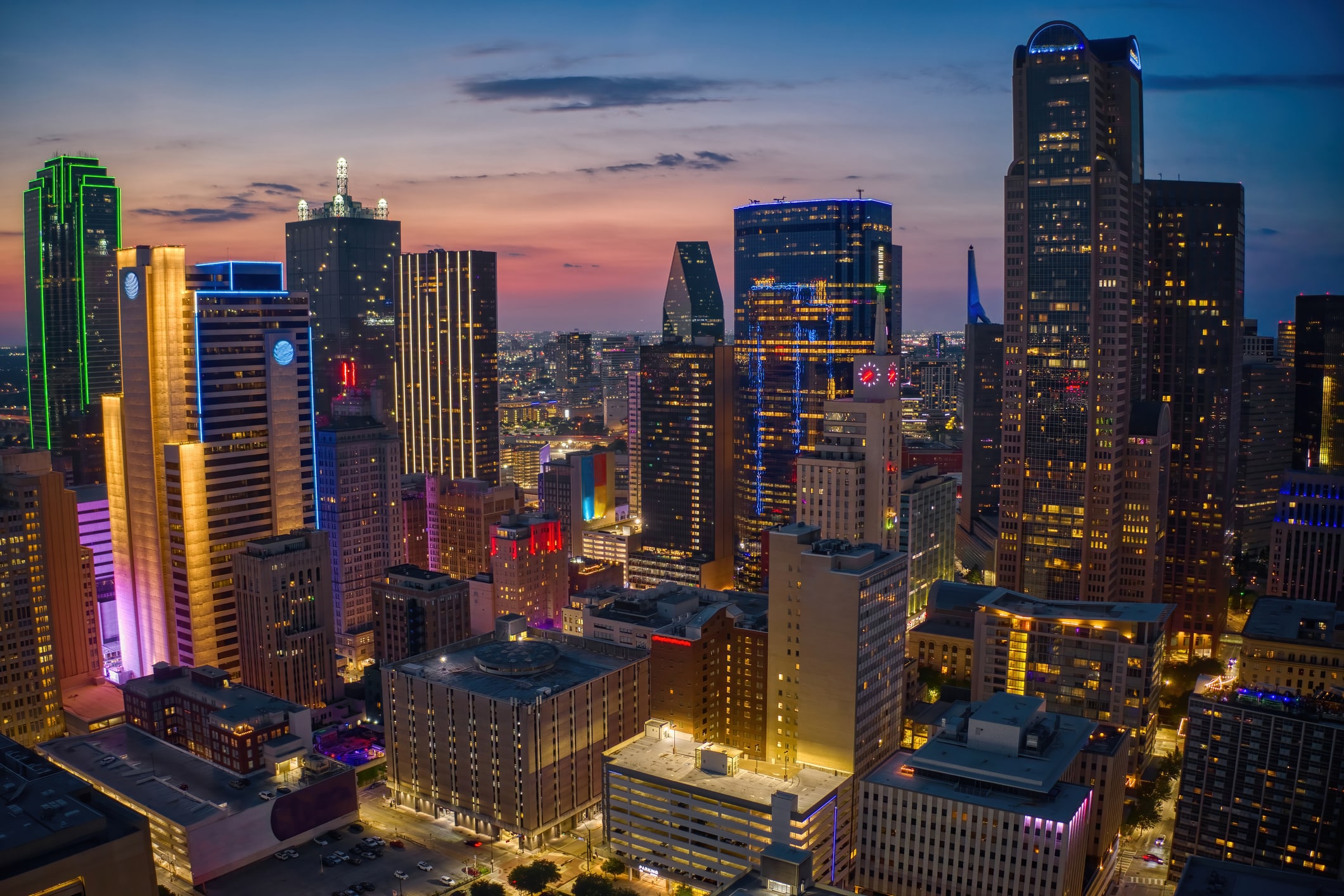 A gorgeous aerial view of downtown Dallas at night, showcasing the city’s vibrant culture, a pro of living in Dallas