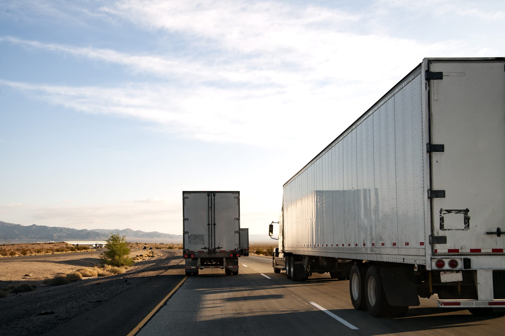 Three moving trucks running along the highway for a long-distance move