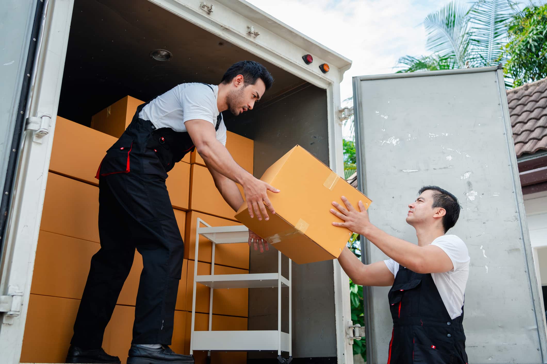 Two long-distance moving professionals loading a moving truck