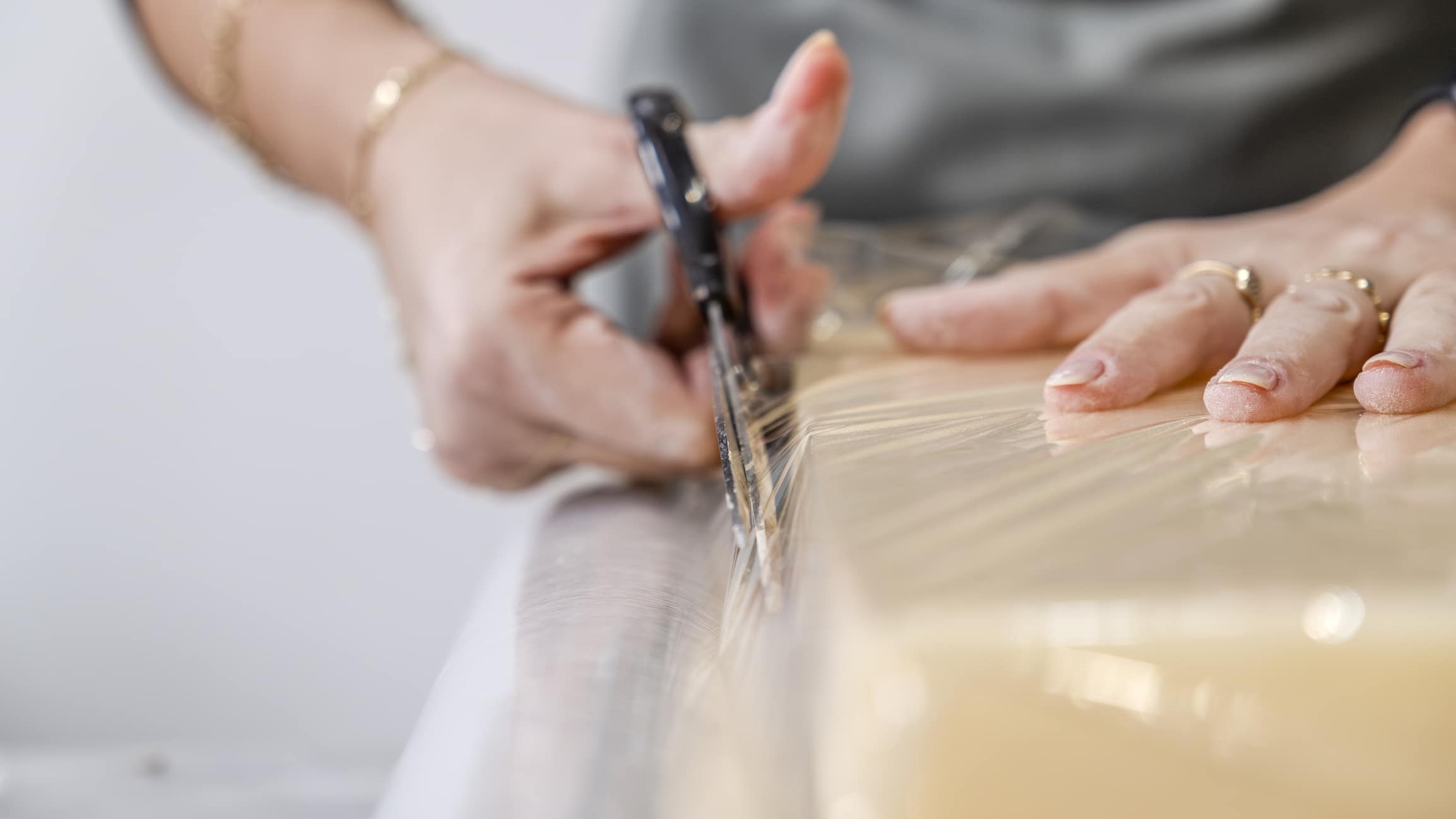 Black man wrapping a chest of drawers with plastic wrap, a packing tip that keeps furniture protected