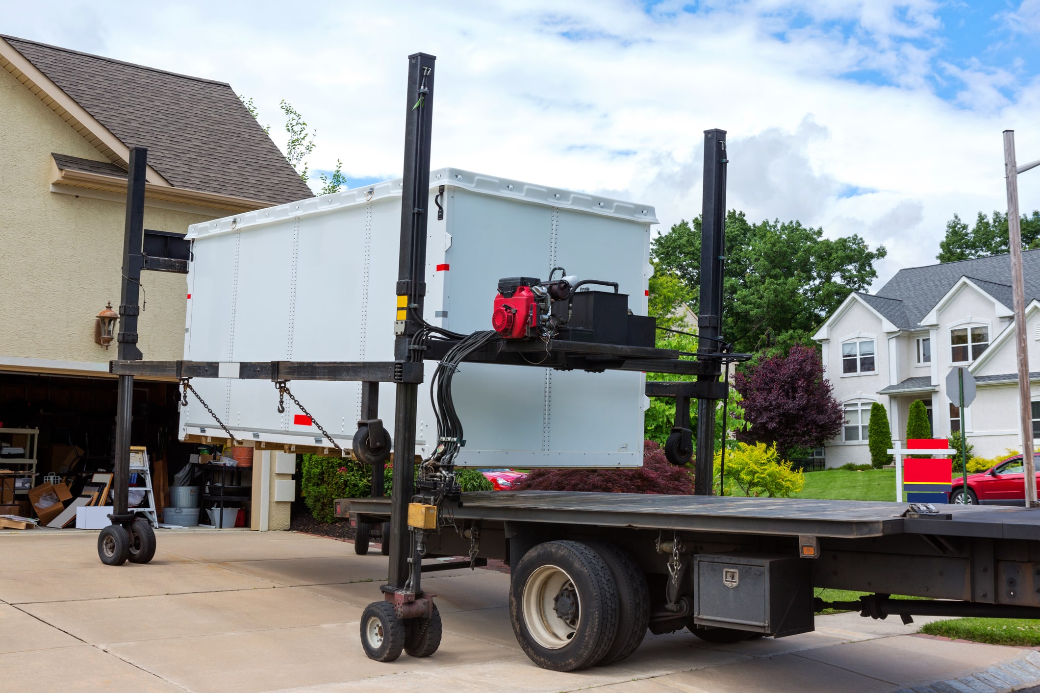 A portable moving container being unloaded onto a driveway for a long-distance move  