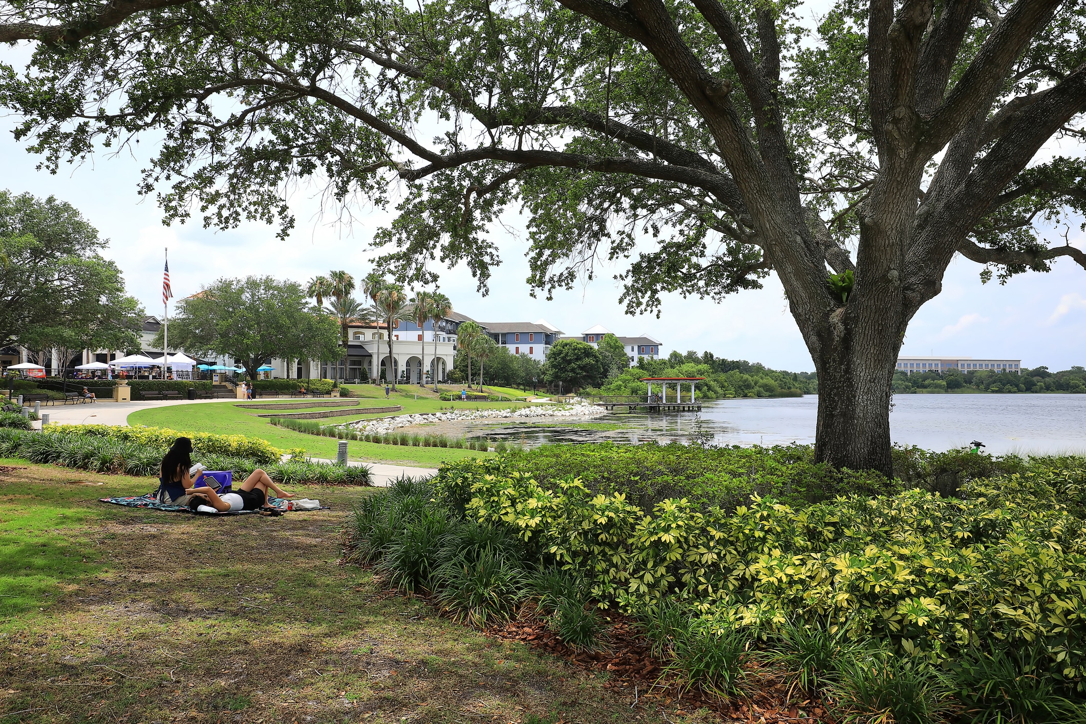 Two women picnicking under a big tree in Baldwin Park, one of the best Orlando neighborhoods