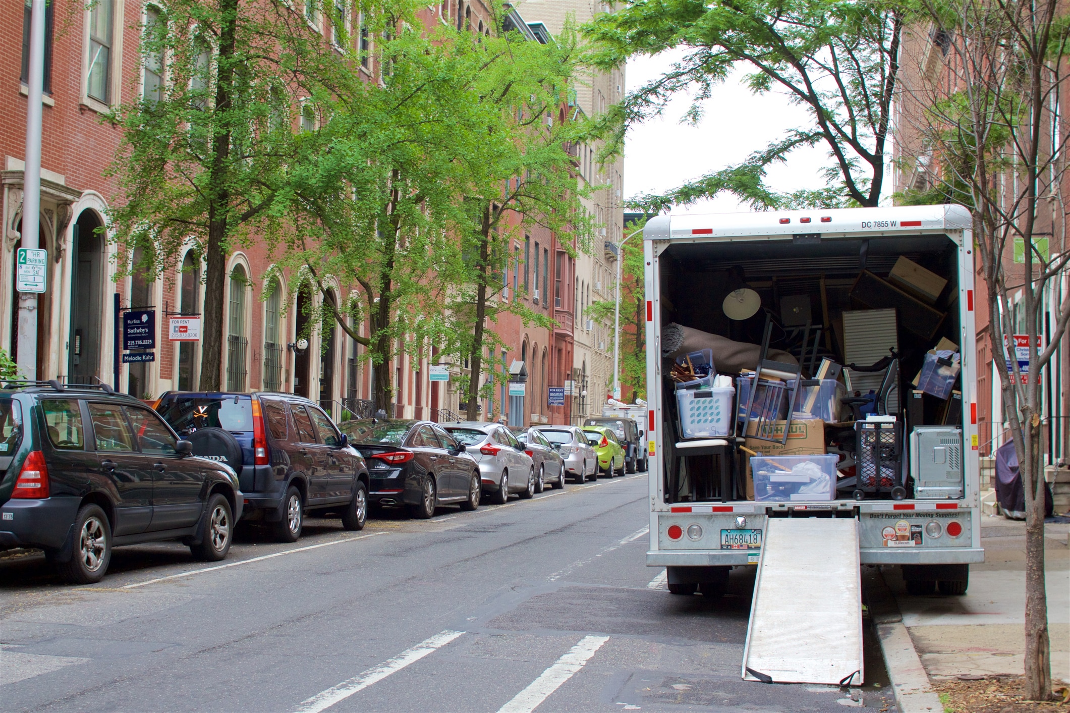 A moving truck parked at a curb preparing for a long-distance move