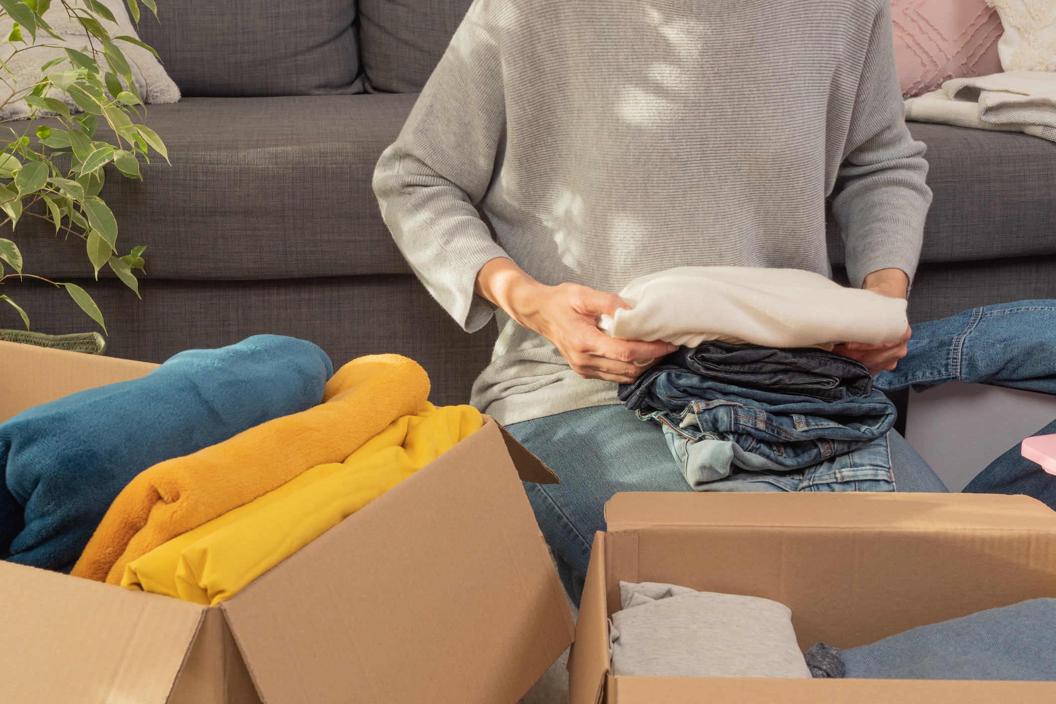 A woman packing her belongings herself to save on her long-distance moving costs