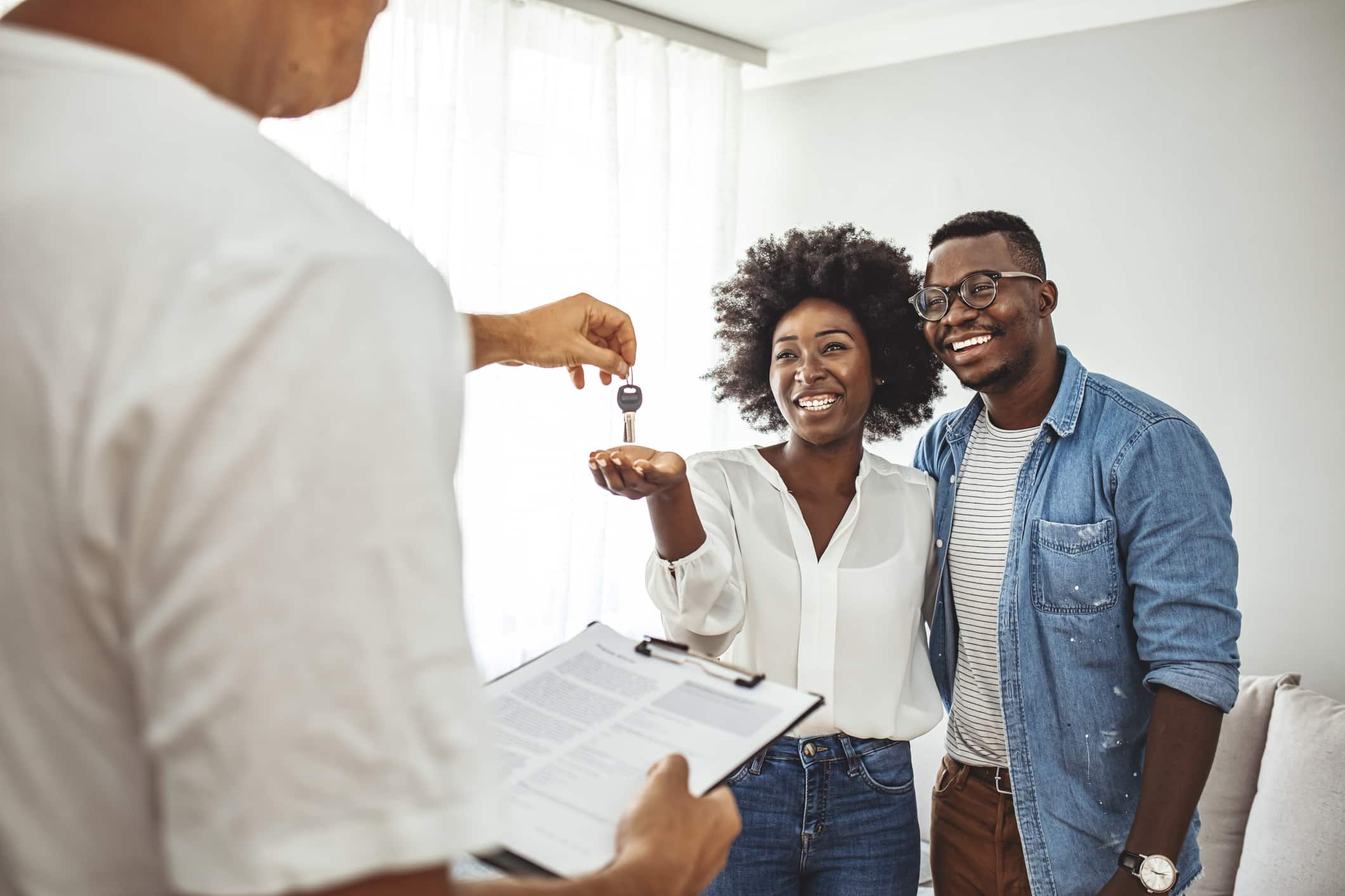 A happy and excited American couple receiving the keys to their new home