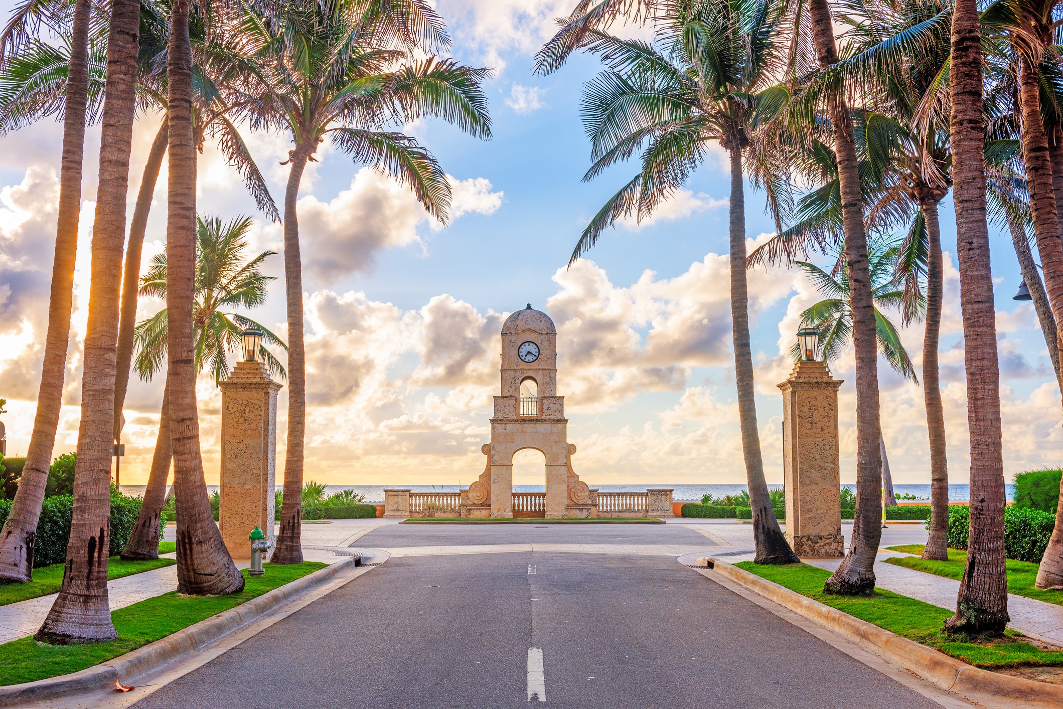 The Worth Avenue Clock Tower framed between palm trees in Palm Beach, Florida