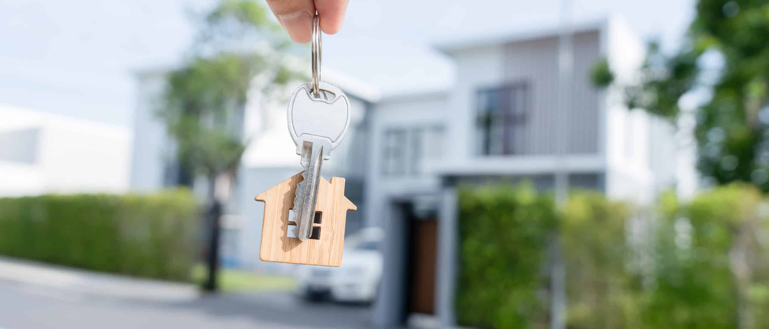 A person carrying their house key as they move into their new home