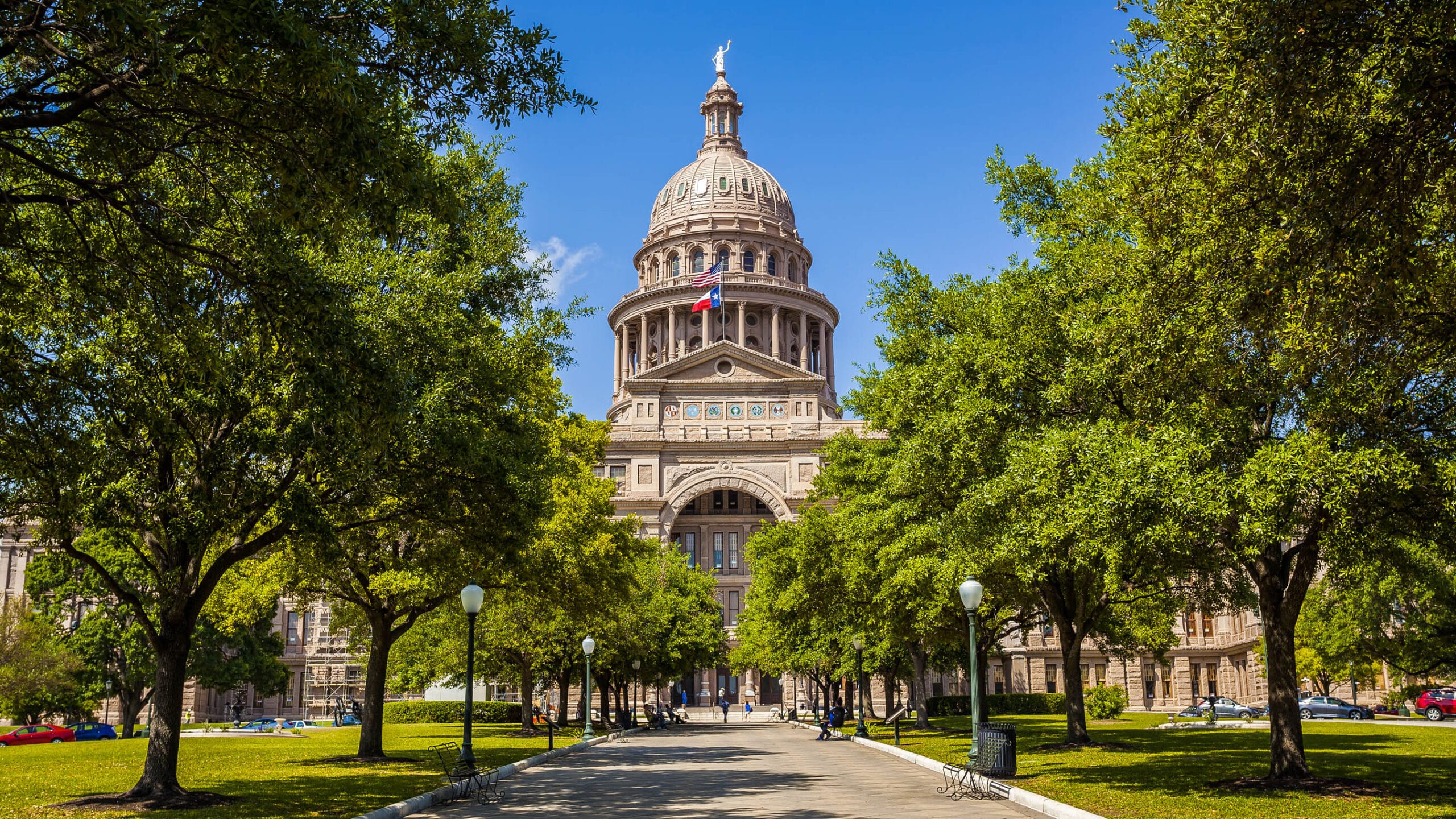 Texas State Capitol Building in Austin, Texas A tree-lined street leading to the Texas State Capitol in downtown Austin on a bright, sunny day