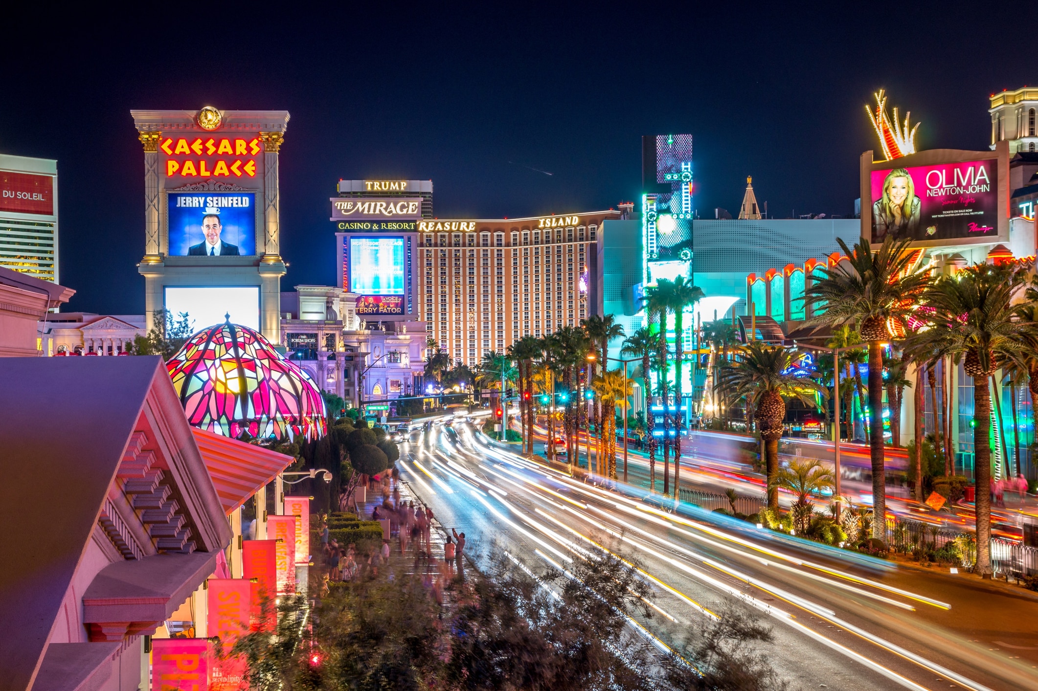 Illuminated City Street And Buildings Against Sky At Night Vibrant Las Vegas Strip at night, featuring the Treasure Island Hotel and Casino and The Mirage