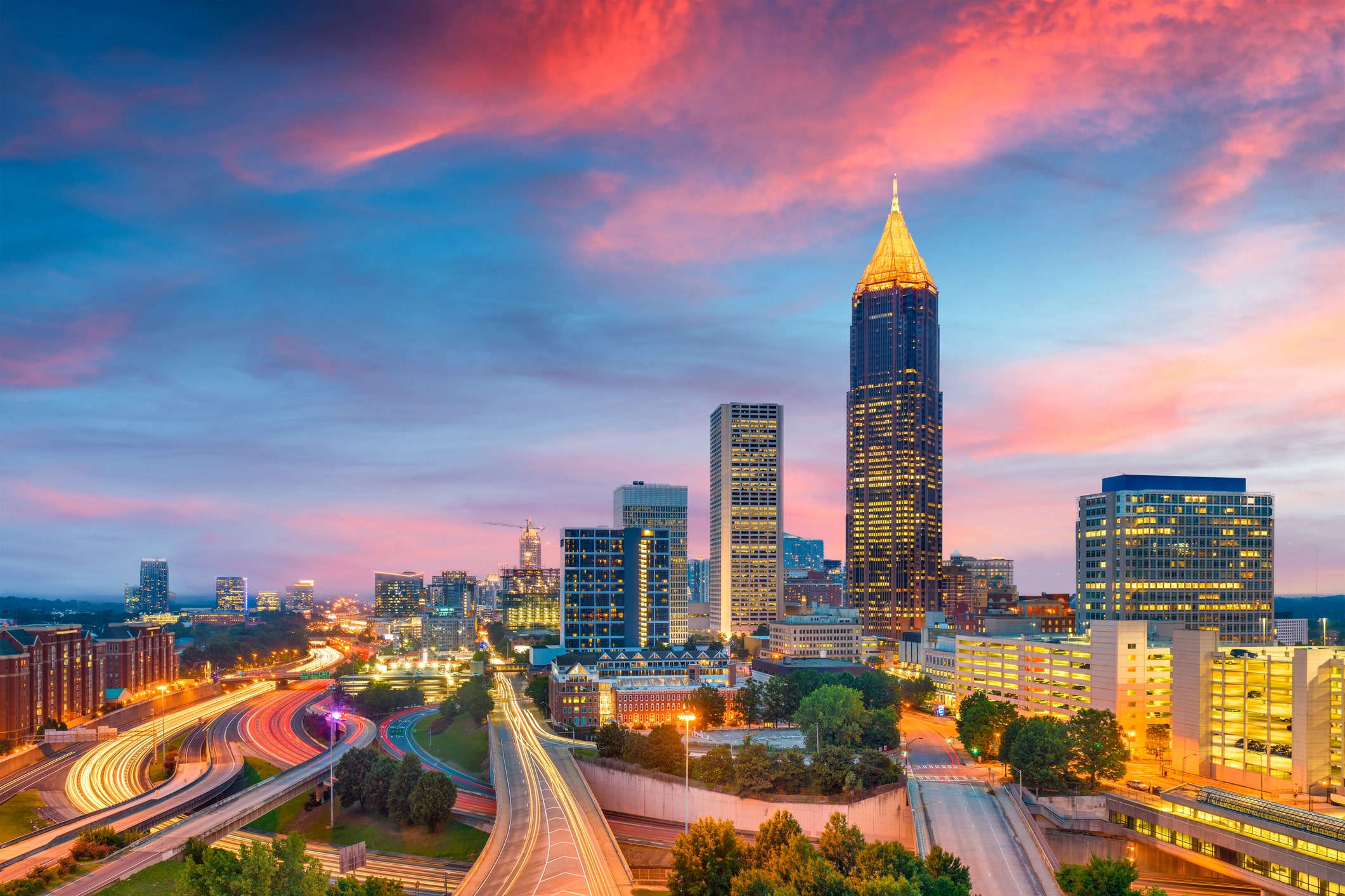 Sunset-pink skies over lit-up skyline of Atlanta at sunset, a beautiful sight for those moving to Atlanta