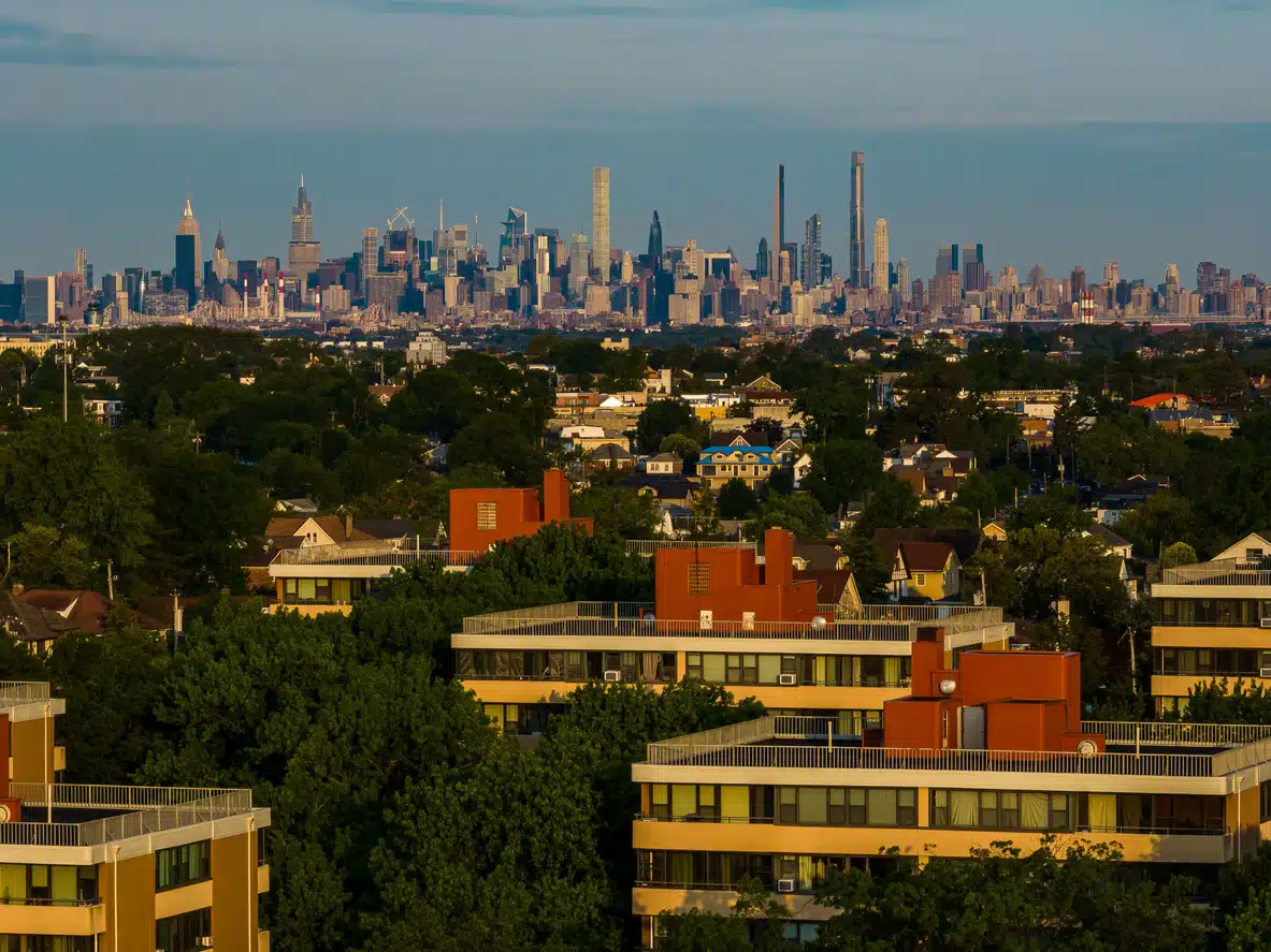 Tree-filled skyline of Queens, New York, with Manhattan visible in the distance