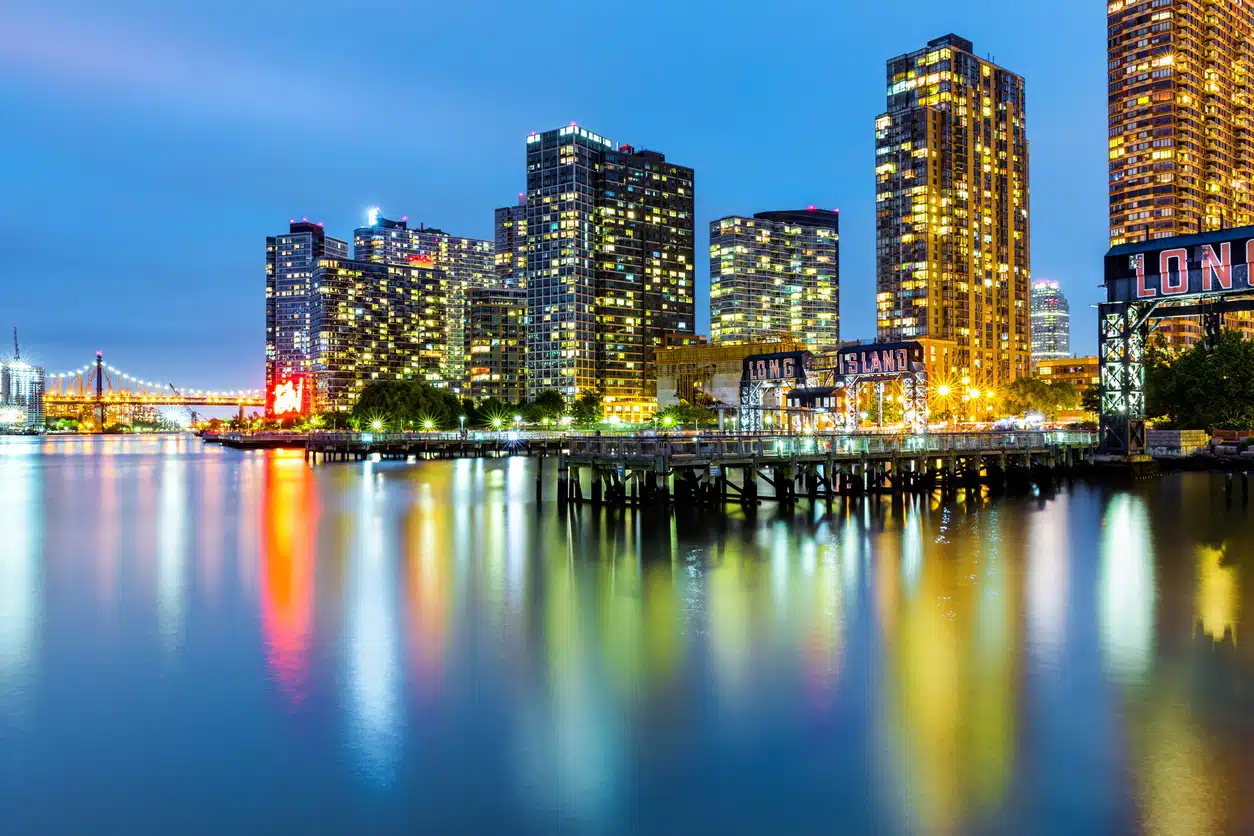 Beautifully illuminated night skyline of Long Island City, Queens, in New York City, with the East River in the foreground