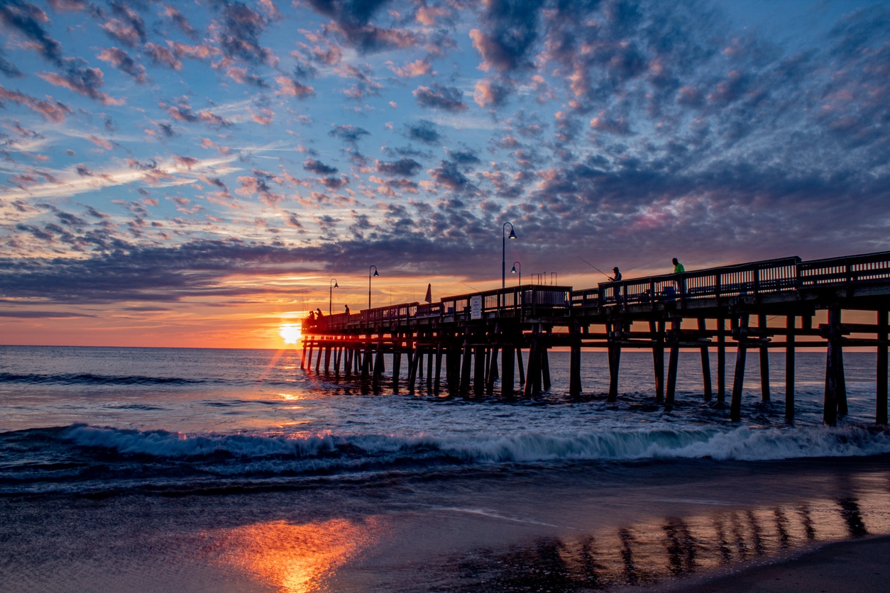 Sunrise at the Sandbridge pier Virginia Beach Fishing Pier at sunset under beautiful cloud formations, a beautiful sight for those moving to Virginia