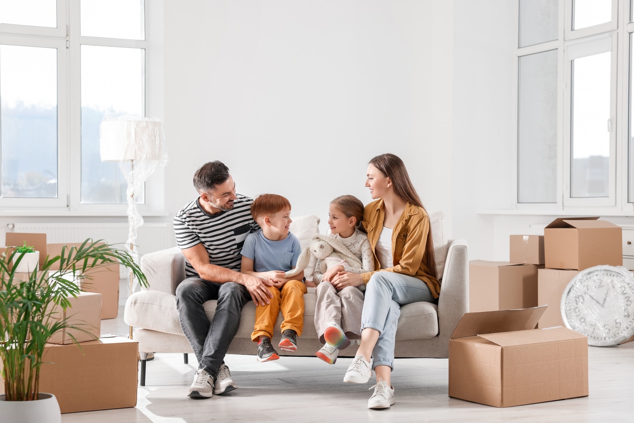 Happy family sitting on couch in new apartment. Moving day iStock-1666096104