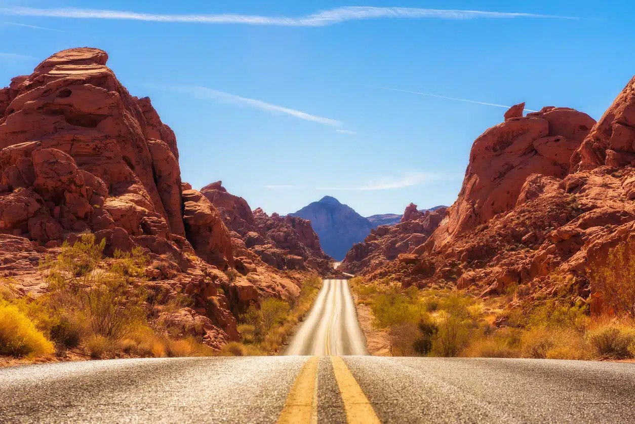 Scenic road winds through red rock formations in Nevada’s Valley of Fire State Park beneath a clear blue desert sky