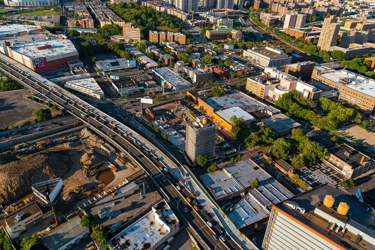 Aerial view of the Bronx, NYC Bronx aerial view showing elevated highway with traffic, surrounding buildings, green areas, and a construction site