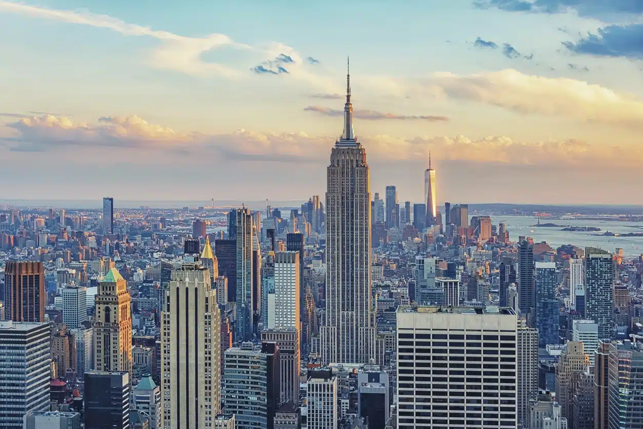 The skyline of New York City, United States Aerial view of NYC skyline at sunset with the Empire State Building, skyscrapers, and water in the distance