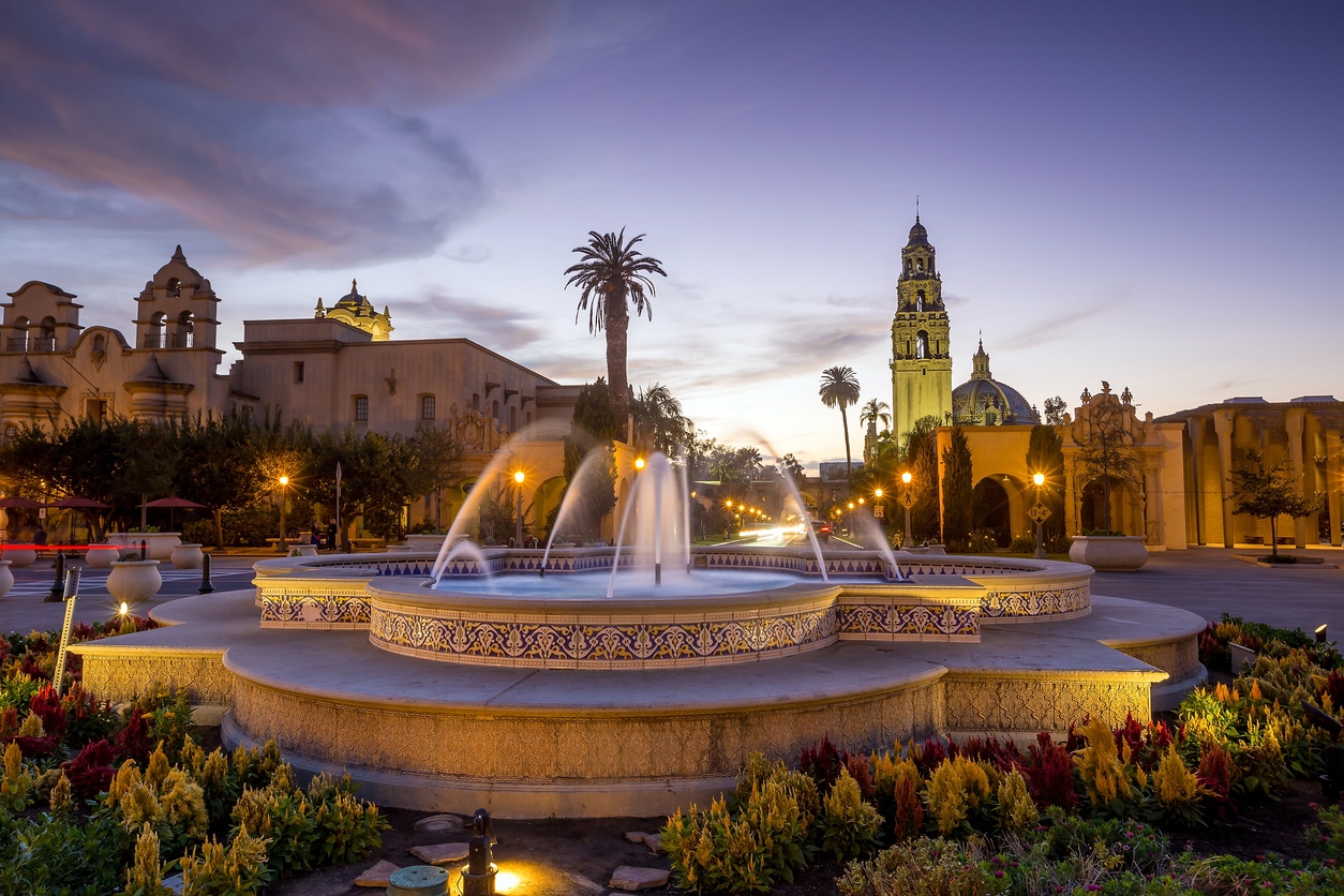 Evening view of Balboa Park in one of the best San Diego neighborhoods, with a lit fountain and Spanish Revival architecture
