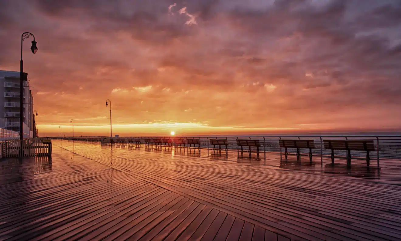 Golden Red Skies Long Beach Boardwalk in one of the best Long Island neighborhoods, with sunset reflecting on the wet planks