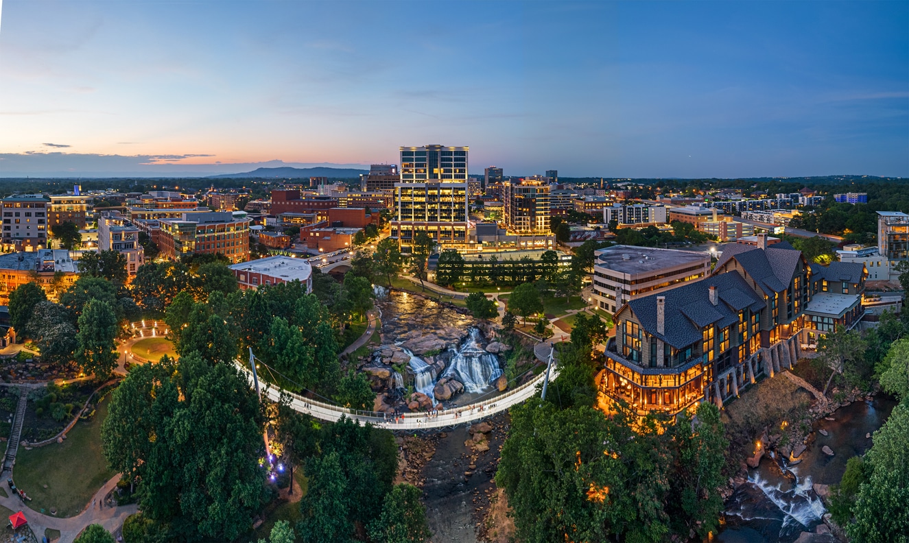 Falls Park on the Reedy in downtown Greenville, SC, featuring the Liberty Bridge and Reedy River waterfalls at dusk